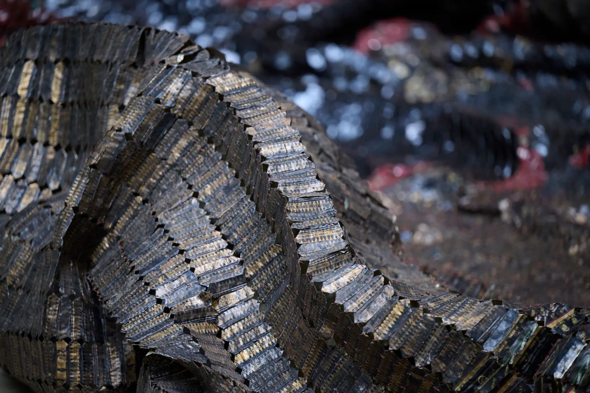 A close up of El Anatsui’s artwork, The Wall, which features sheets of black metal.