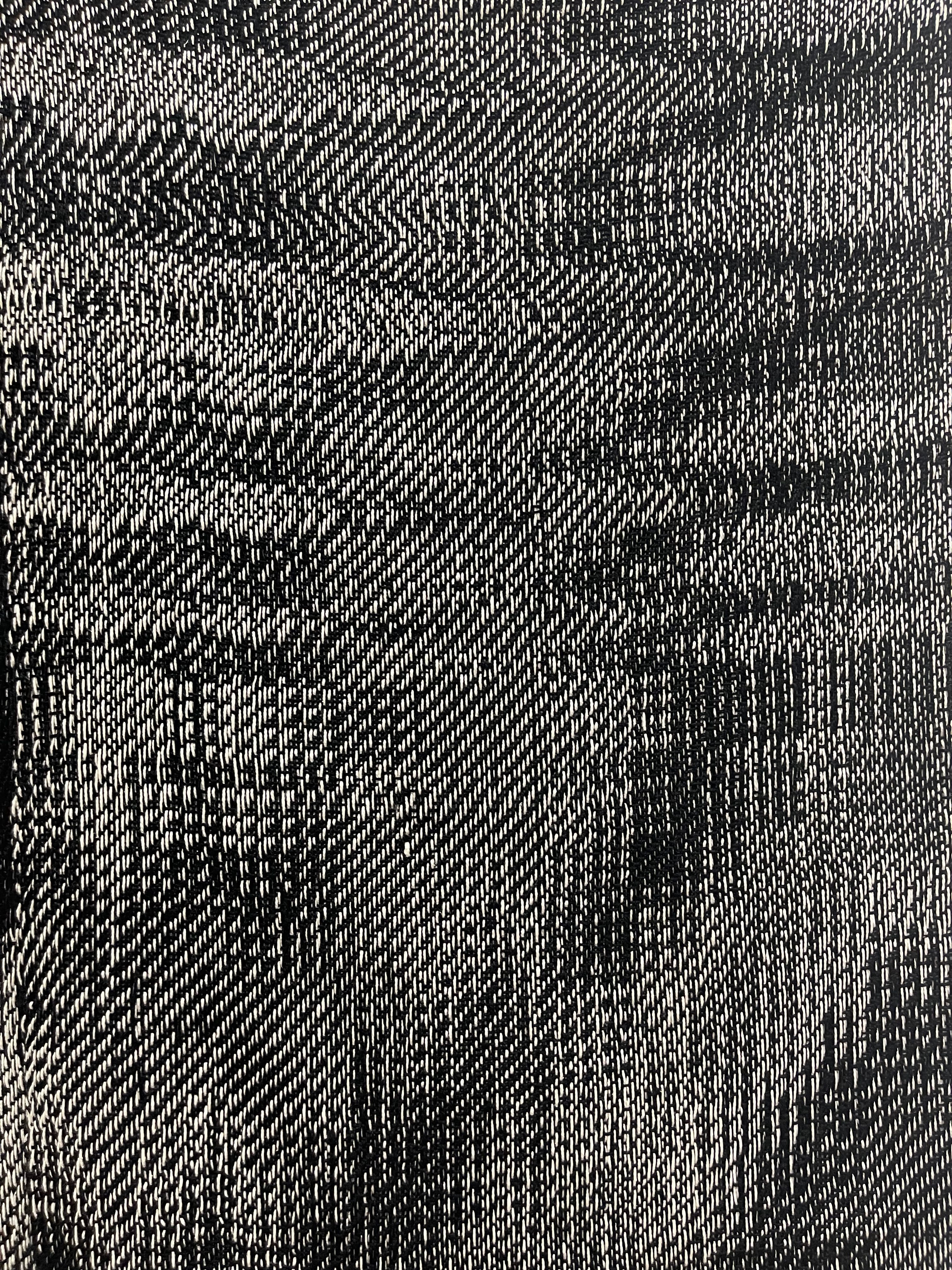 A detailed black-and-white woven pattern with a dynamic, wave-like texture.