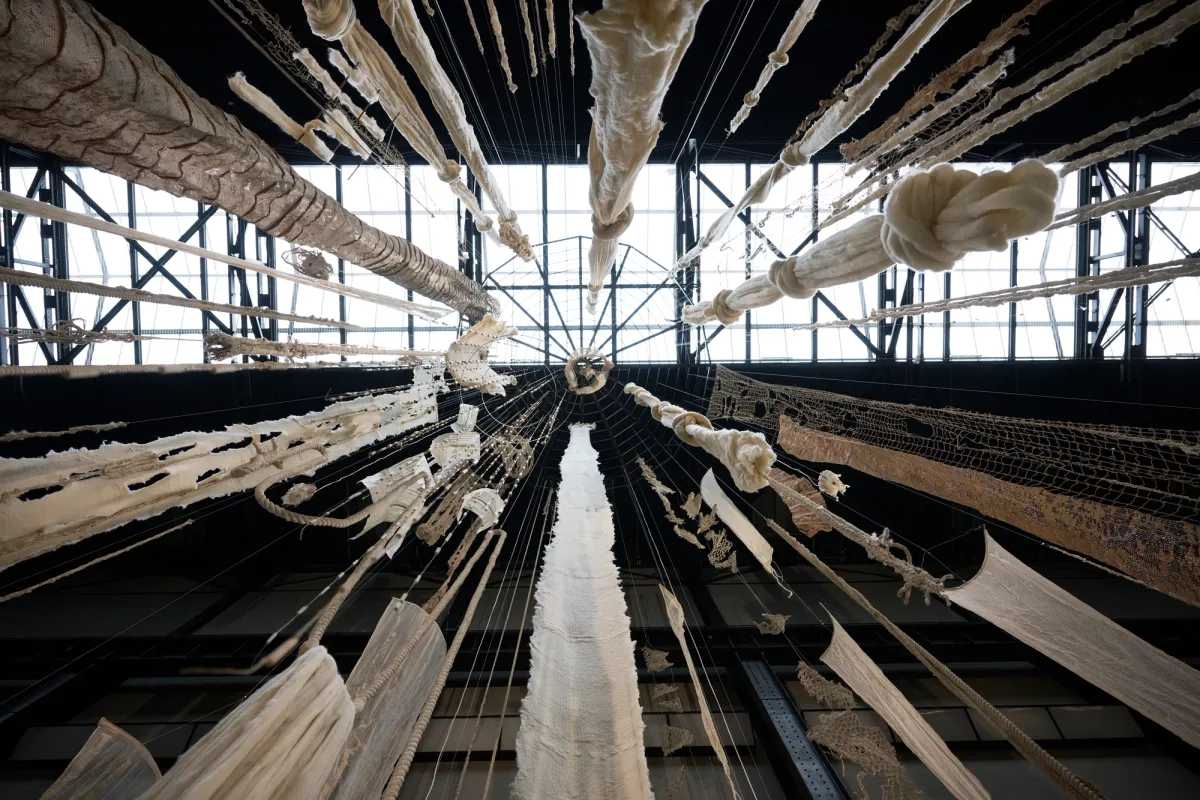 A large wind chime installation viewed from a worm's eye view at Tate Modern.