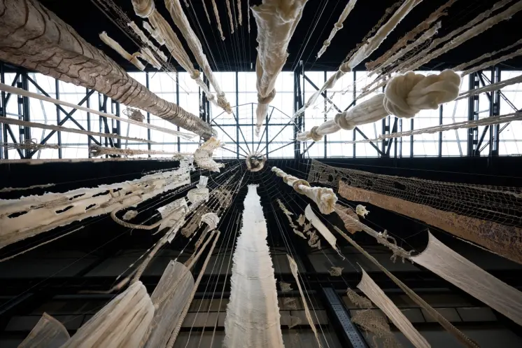 A large wind chime installation viewed from a worm's eye view at Tate Modern.