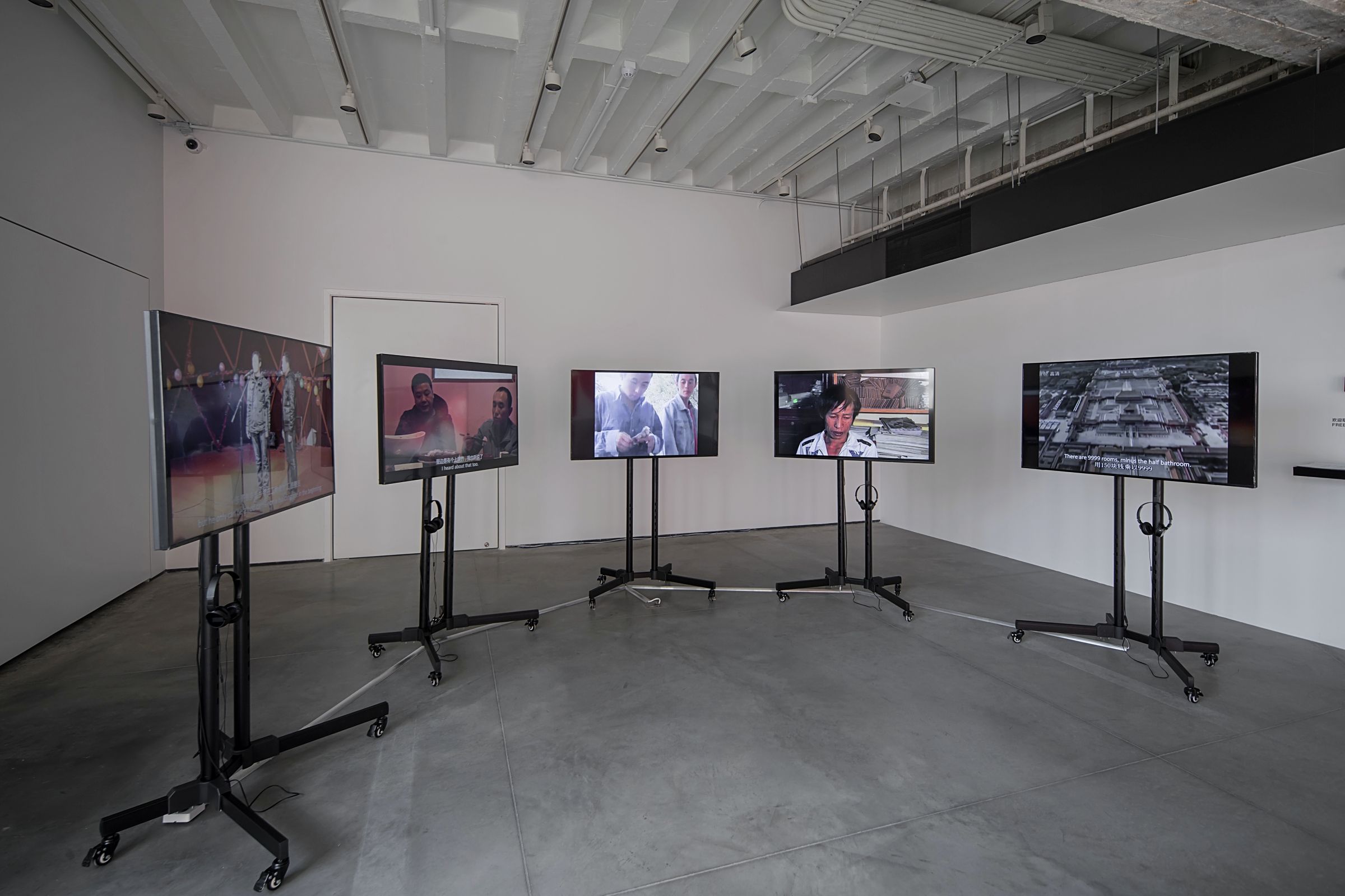 Gallery with mounted screens showing different videos.