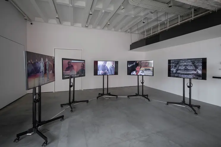 Gallery with mounted screens showing different videos.