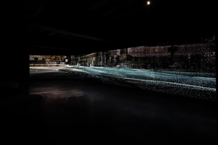 An artistic, blurry photograph capturing a cityscape on a rainy night, the road lined with indistinct buildings highlighte...