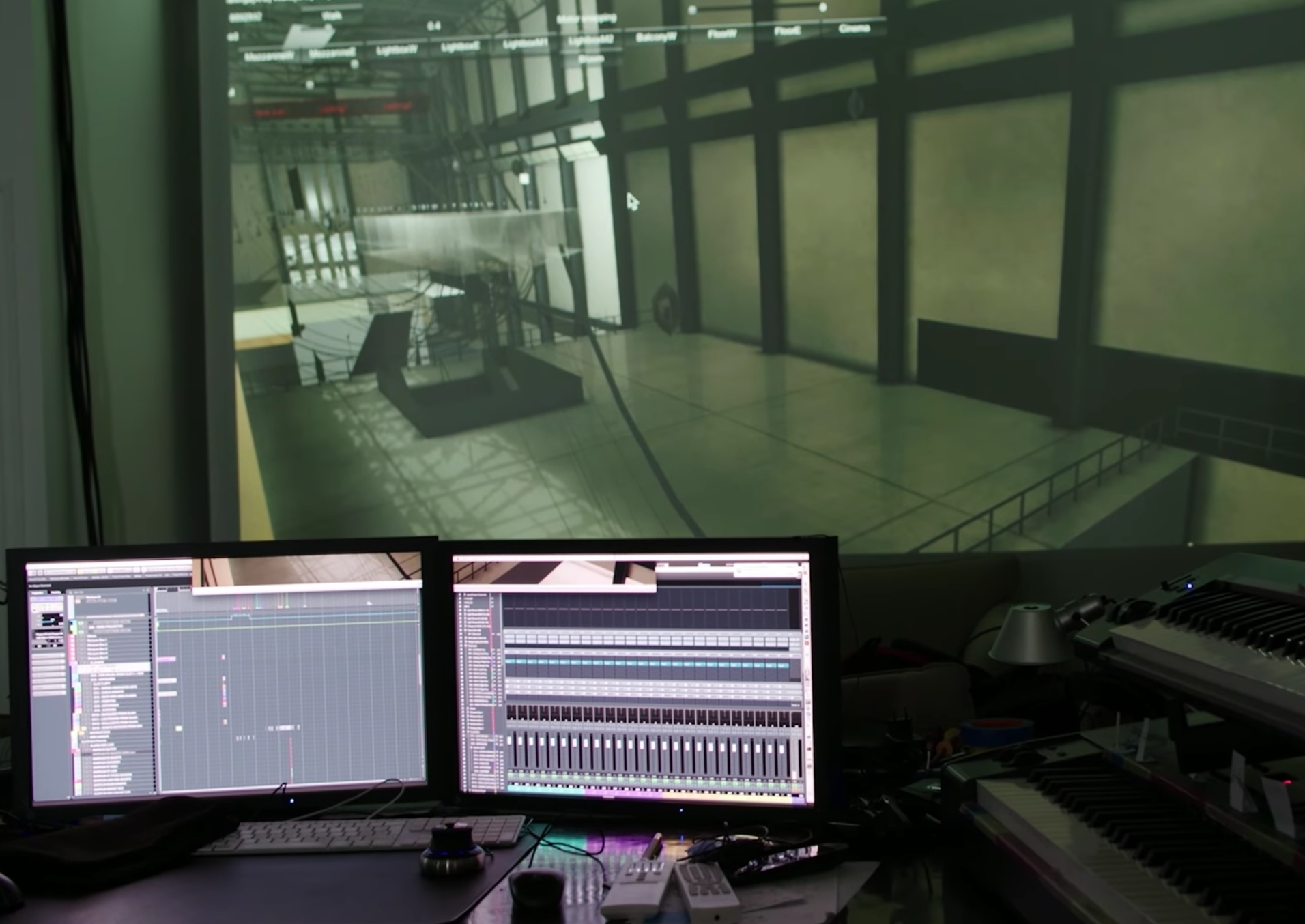 A workspace is composed of two computers on a desk with audio recording software open screening on both. A larger monitor ...