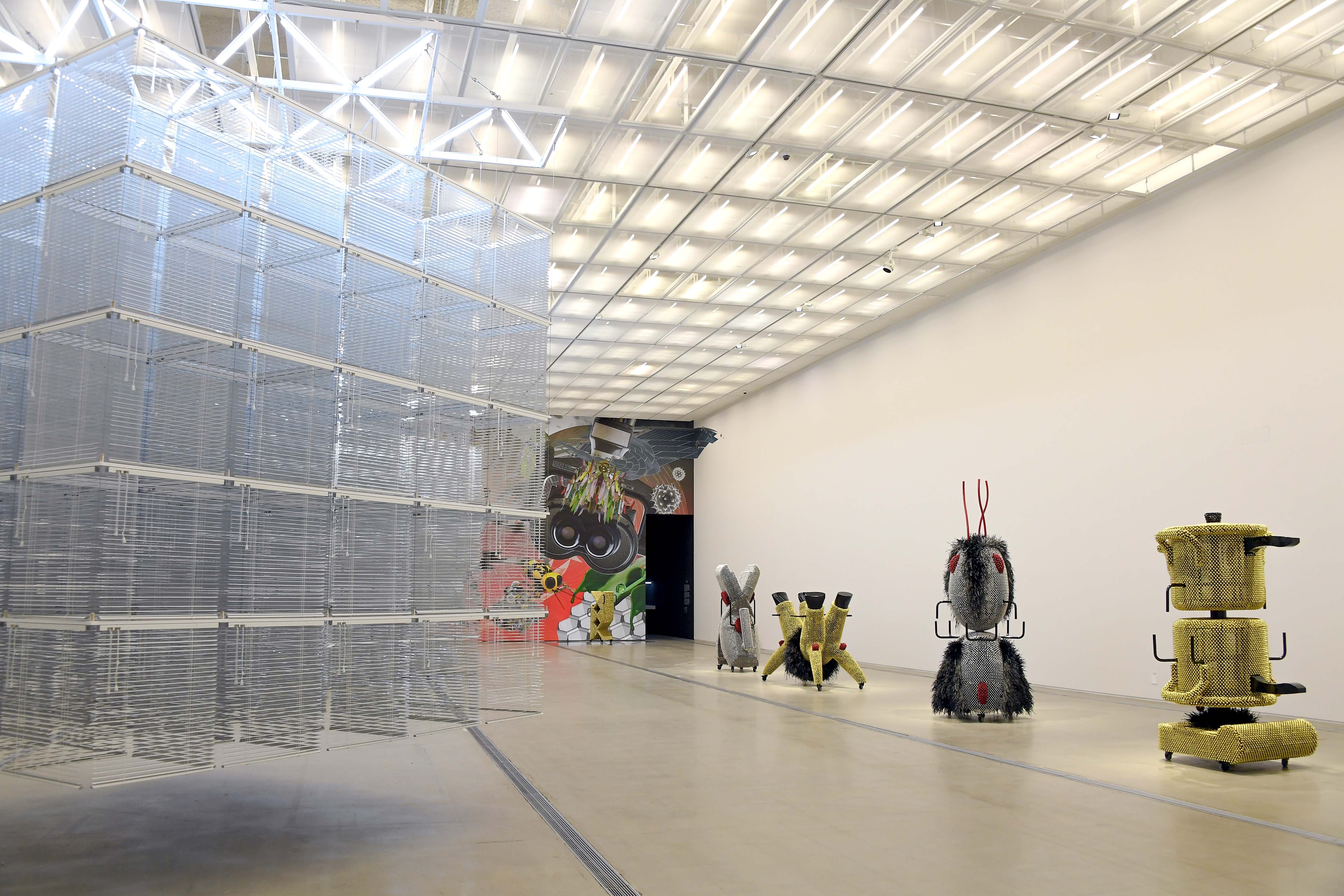 Art installation featuring objects adorned with silver and gold metal pins, reminiscent of toys.