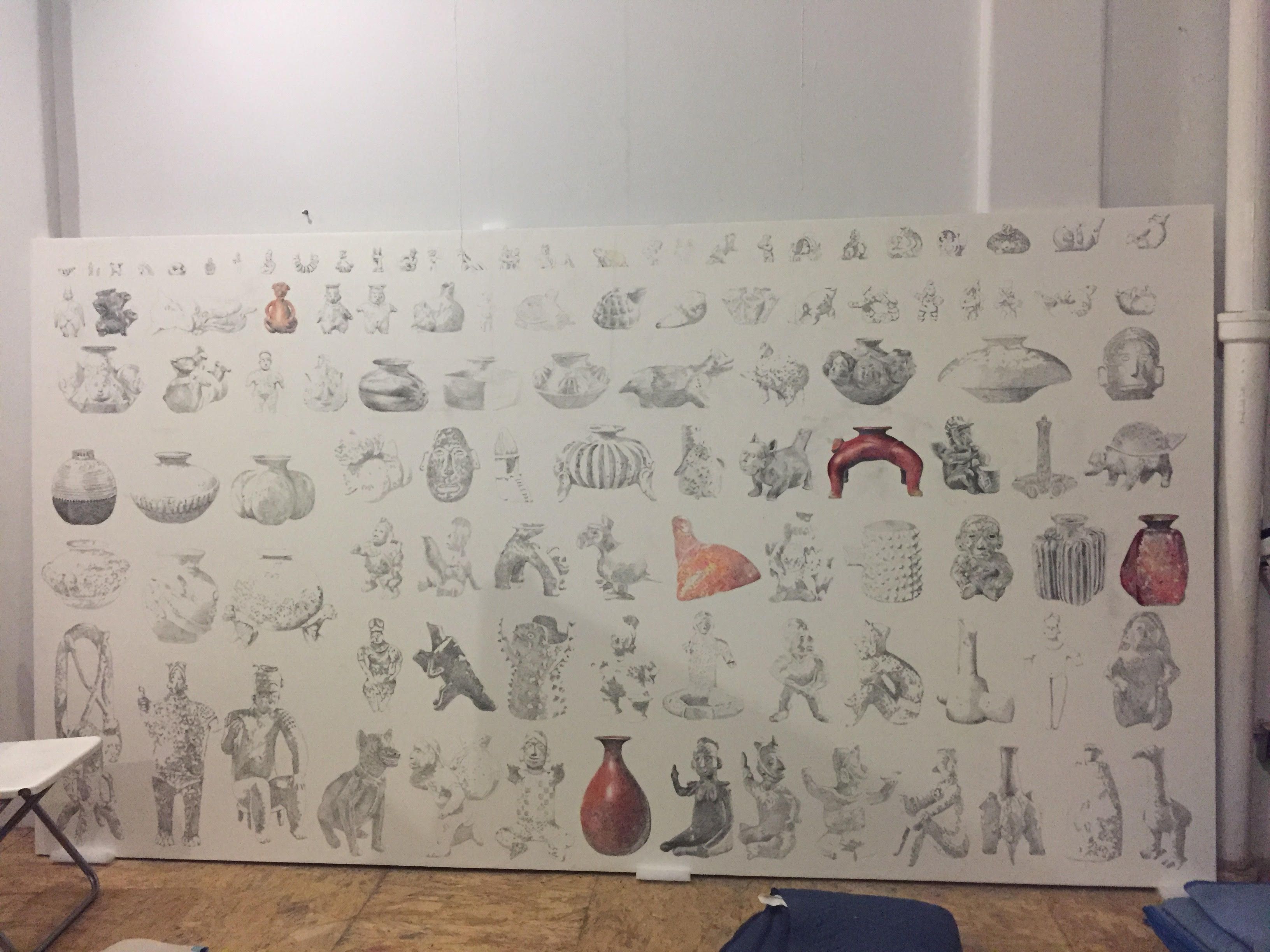 A partially completed mural with black-and-white sketches and a few colored pottery pieces on a white backdrop.