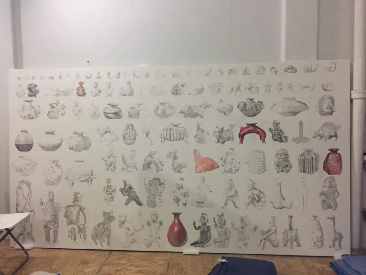 A partially completed mural with black-and-white sketches and a few colored pottery pieces on a white backdrop.