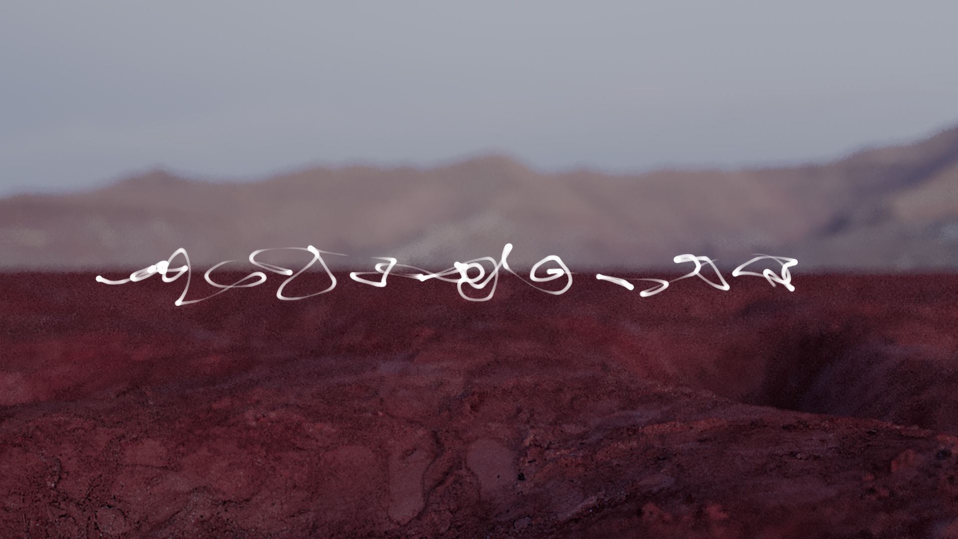 White abstract line formations floating above a reddish desert landscape with mountains in the distance.