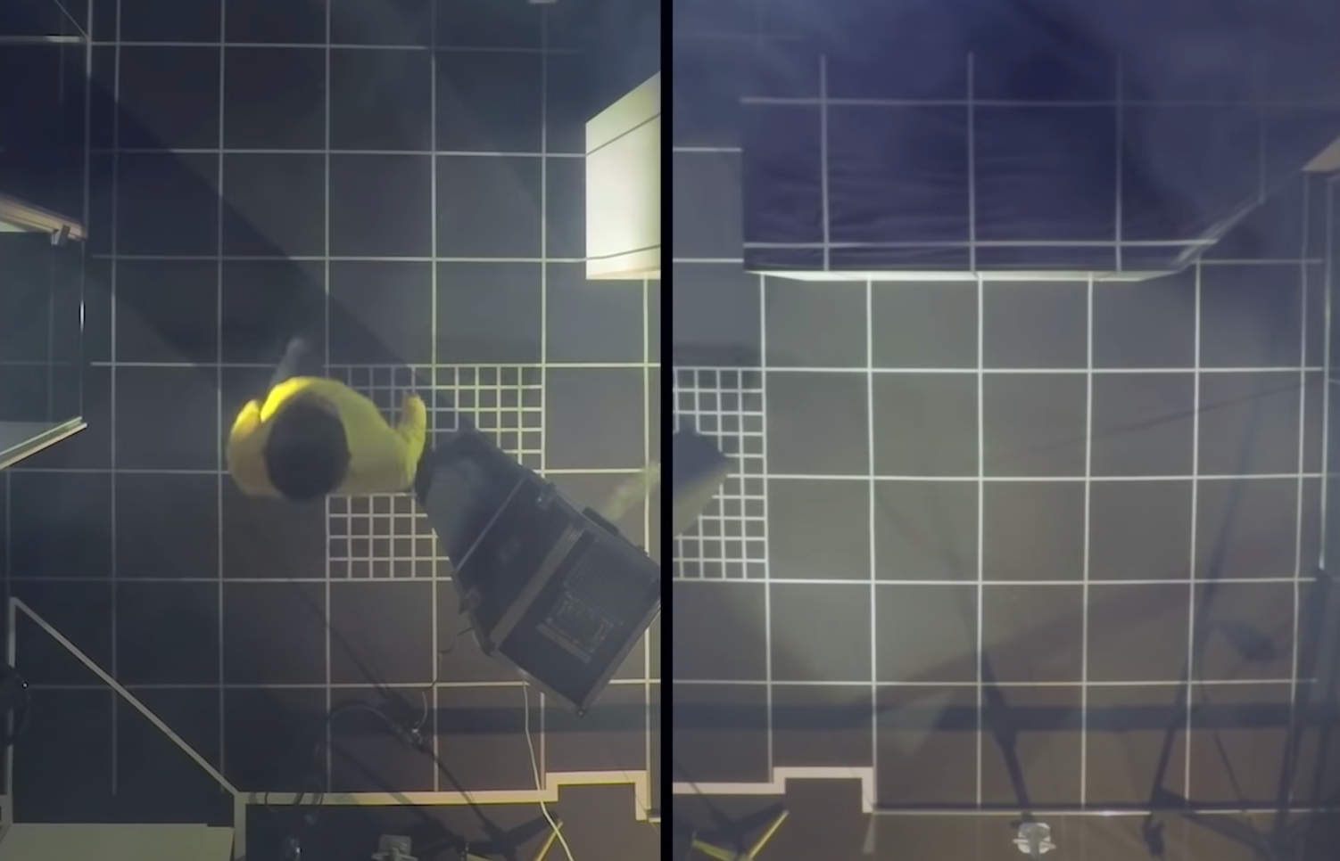 An overhead view of a person in a yellow shirt walking on a grid-like floor composed of black square tiles separated by wh...
