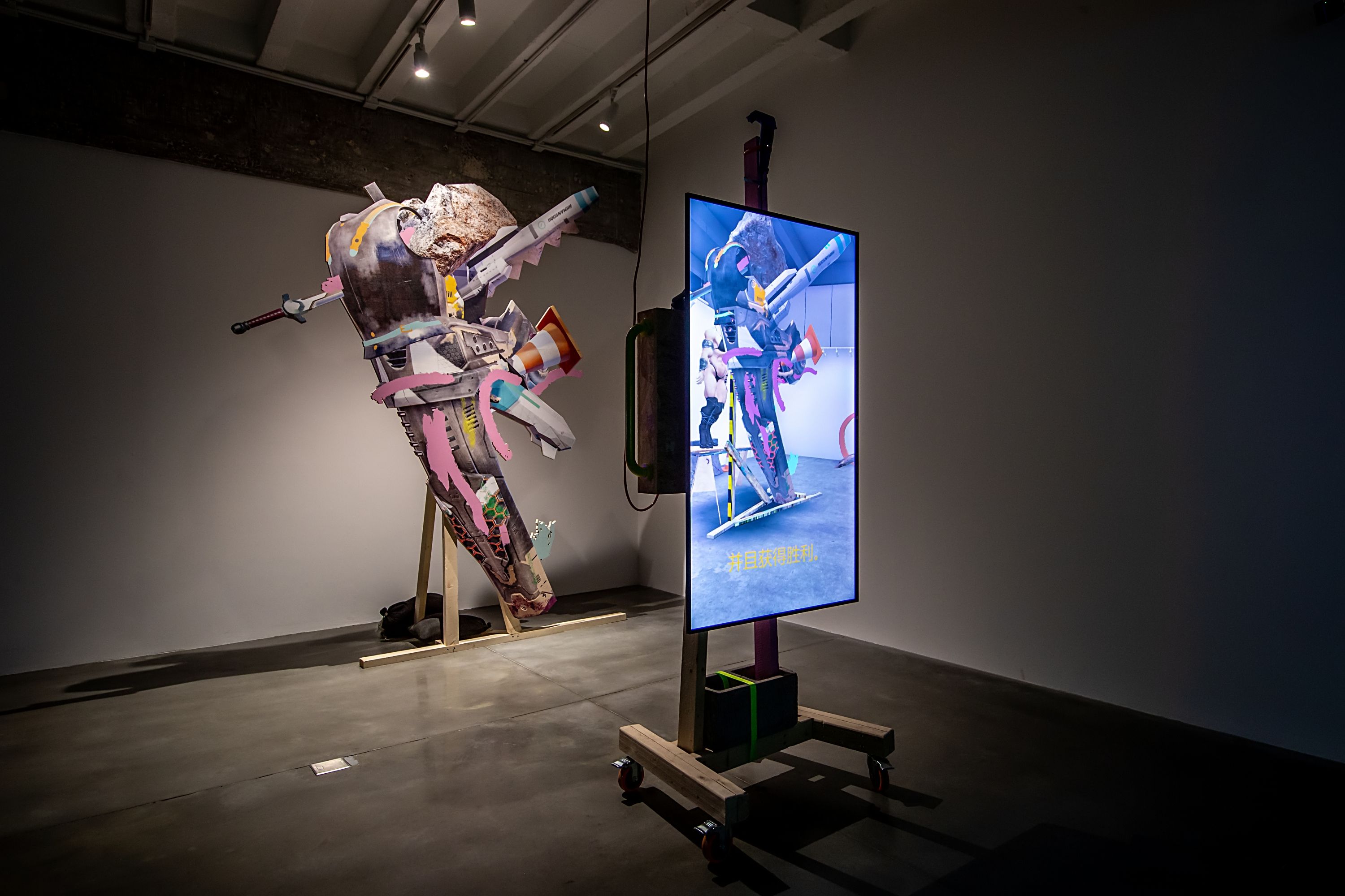 Art installation featuring various objects, including a sword and rocket, assembled to form a towering structure.
