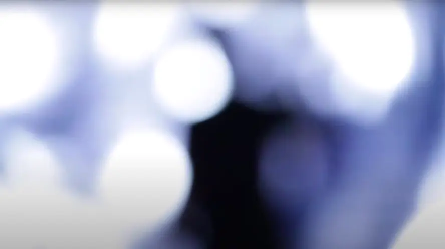 An abstract, blurred image composed of white, blue, and black hues, suggesting a depiction of space exploration.