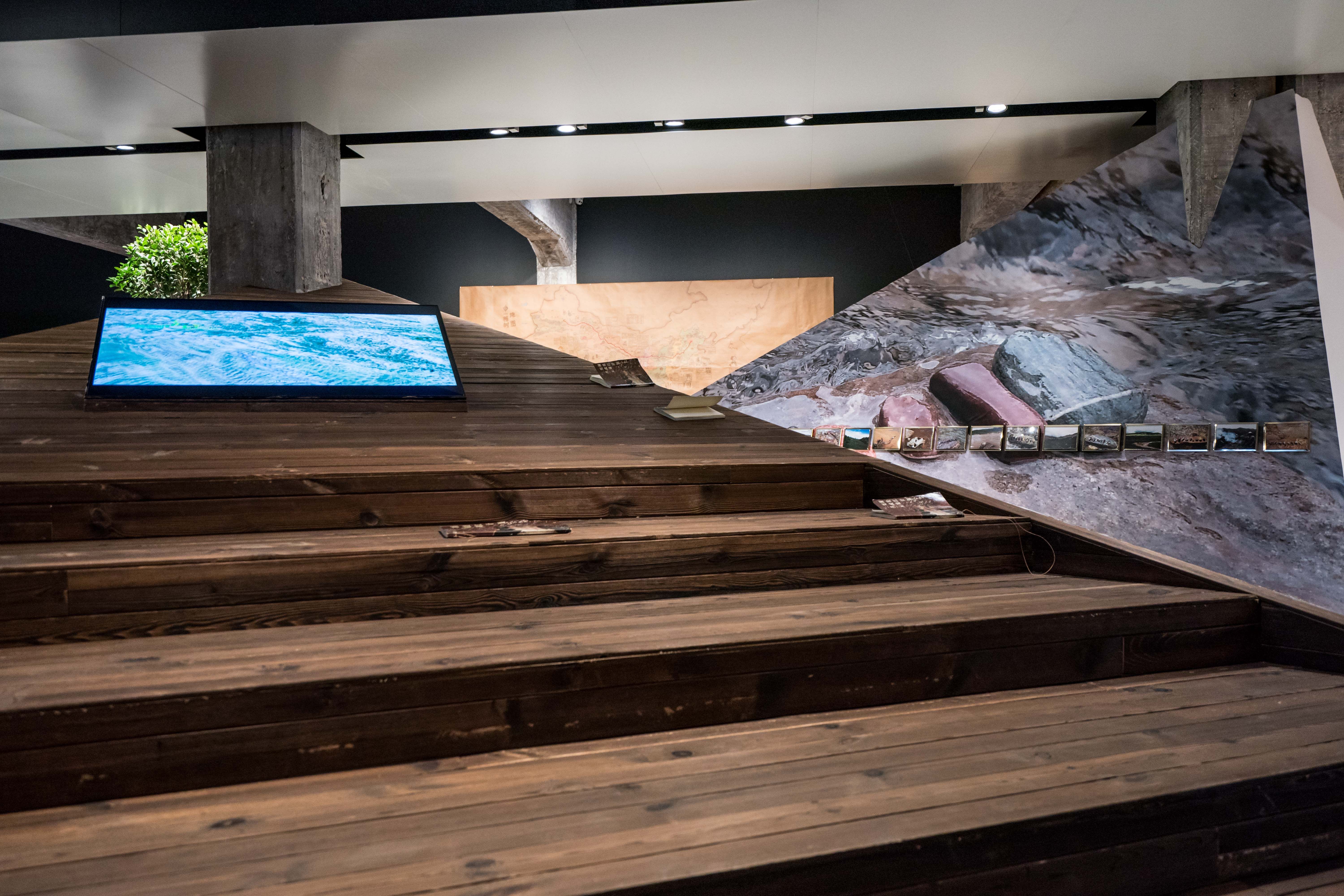 Multimedia installation with screens on wooden ramp.