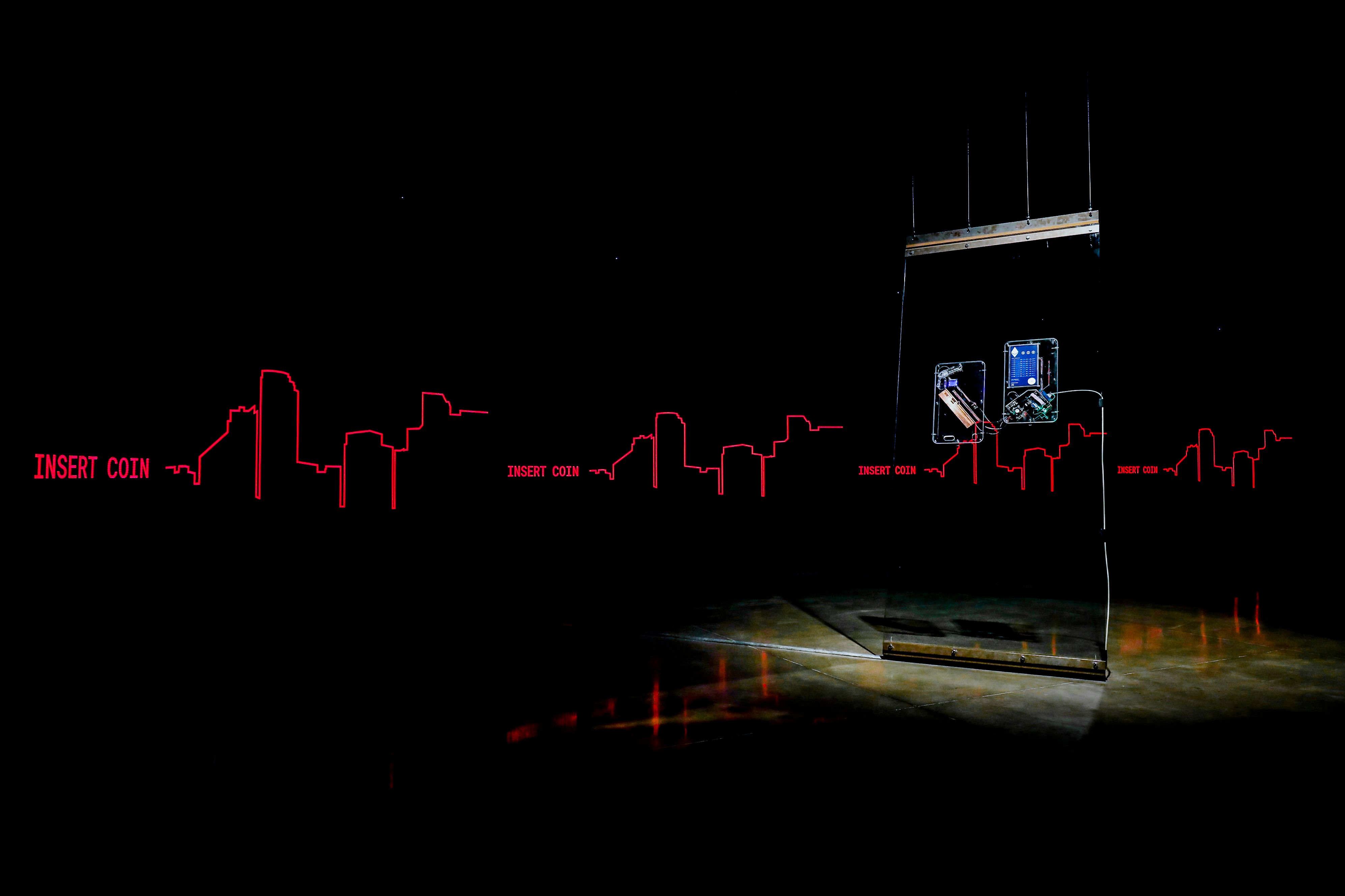 Dark room with neon red 'INSERT COIN' text and hanging electronic devices.