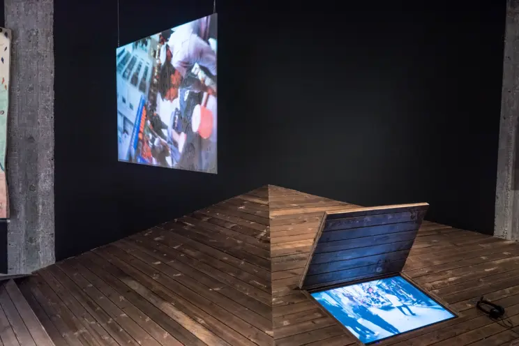 Multimedia installation with projection on wooden ramp.