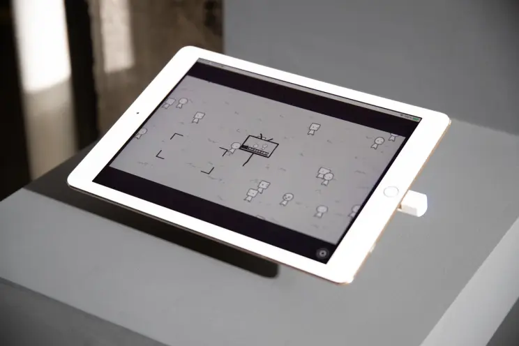 Close-up of a tablet displaying a minimalist black and white drawing.