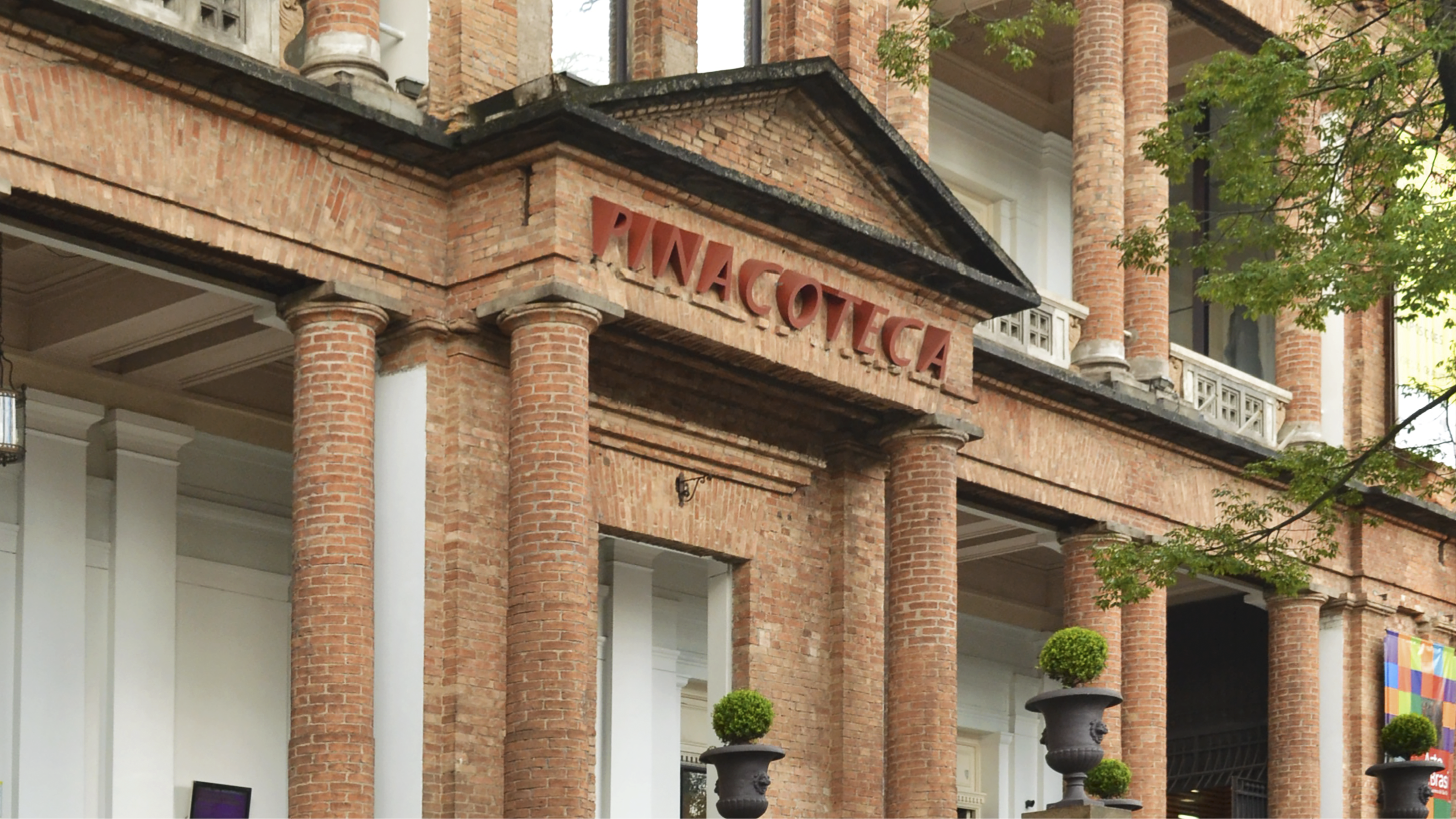 Facade of the Pinacoteca de São Paulo, a historic art museum in Brazil, featuring red brick columns and classical architec...