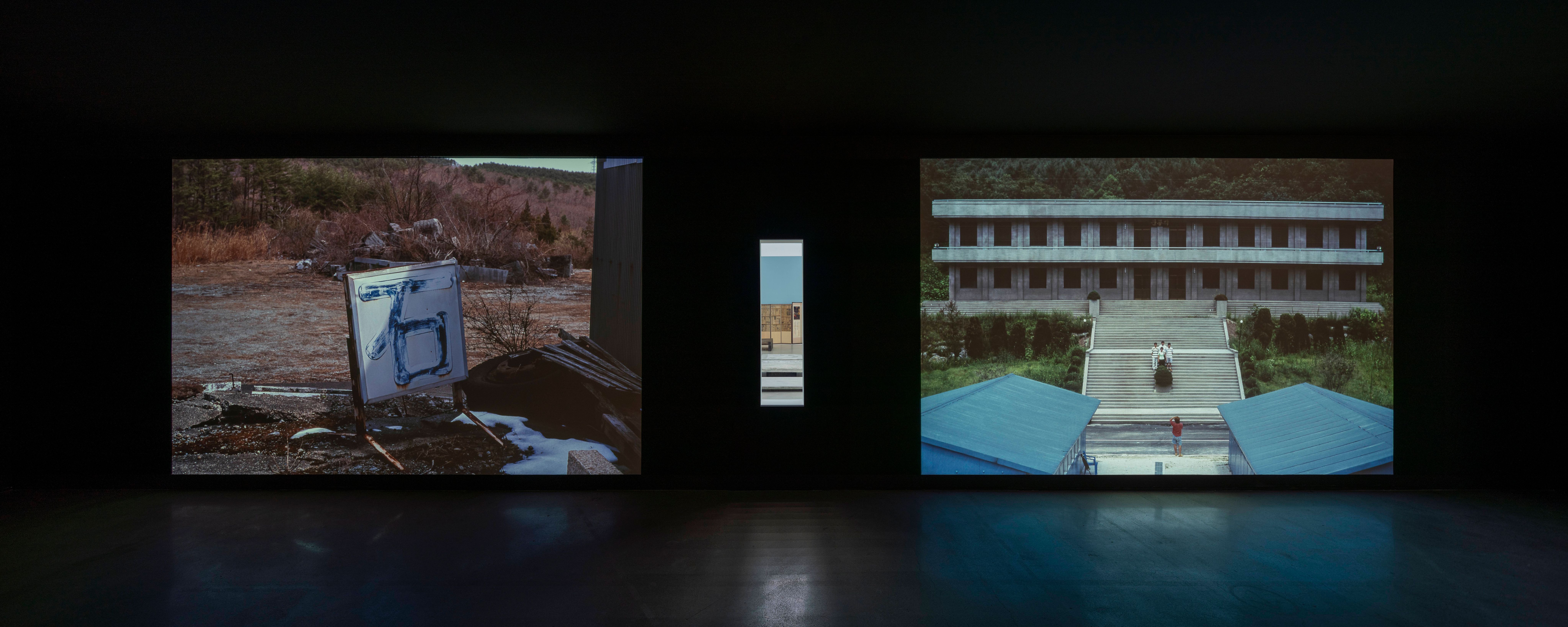 Three outdoor photographs on display showcasing various buildings and landscapes.