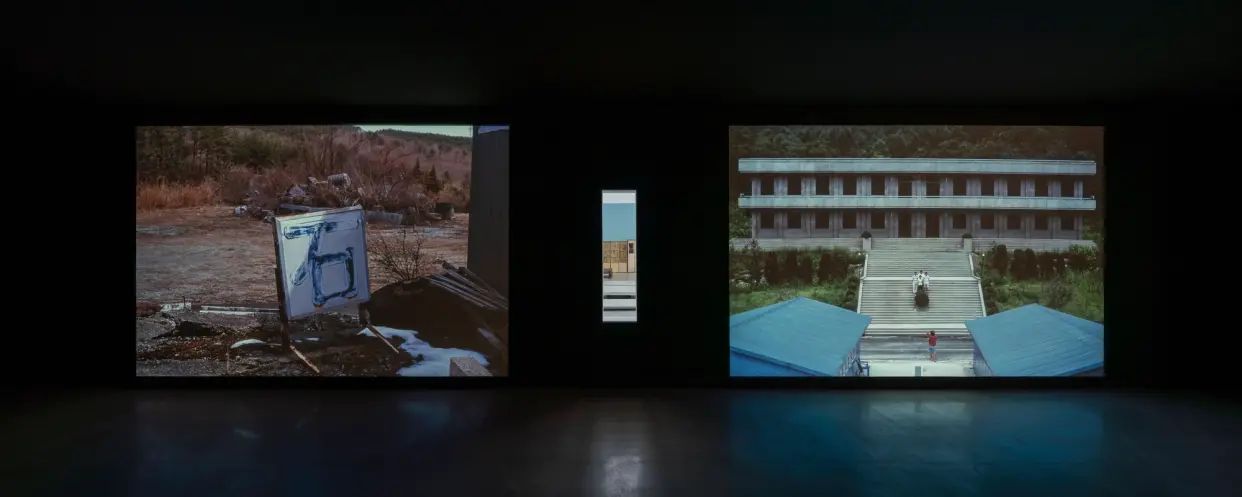 Three outdoor photographs on display showcasing various buildings and landscapes.