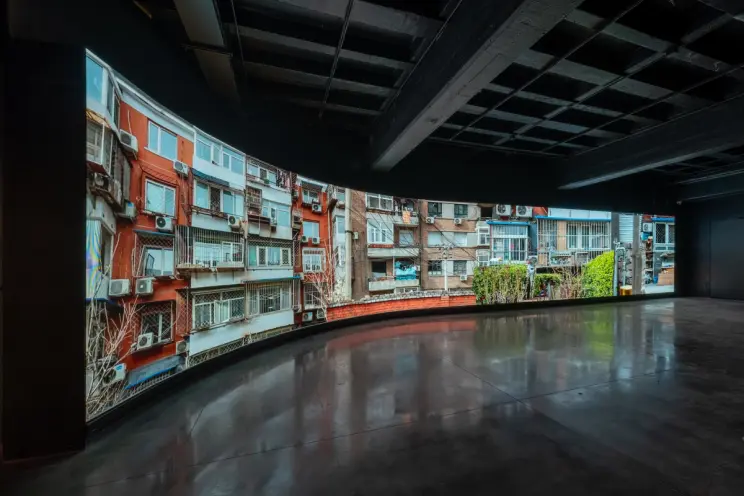 Spacious room featuring a wall-sized photograph of a colorful apartment building facade.