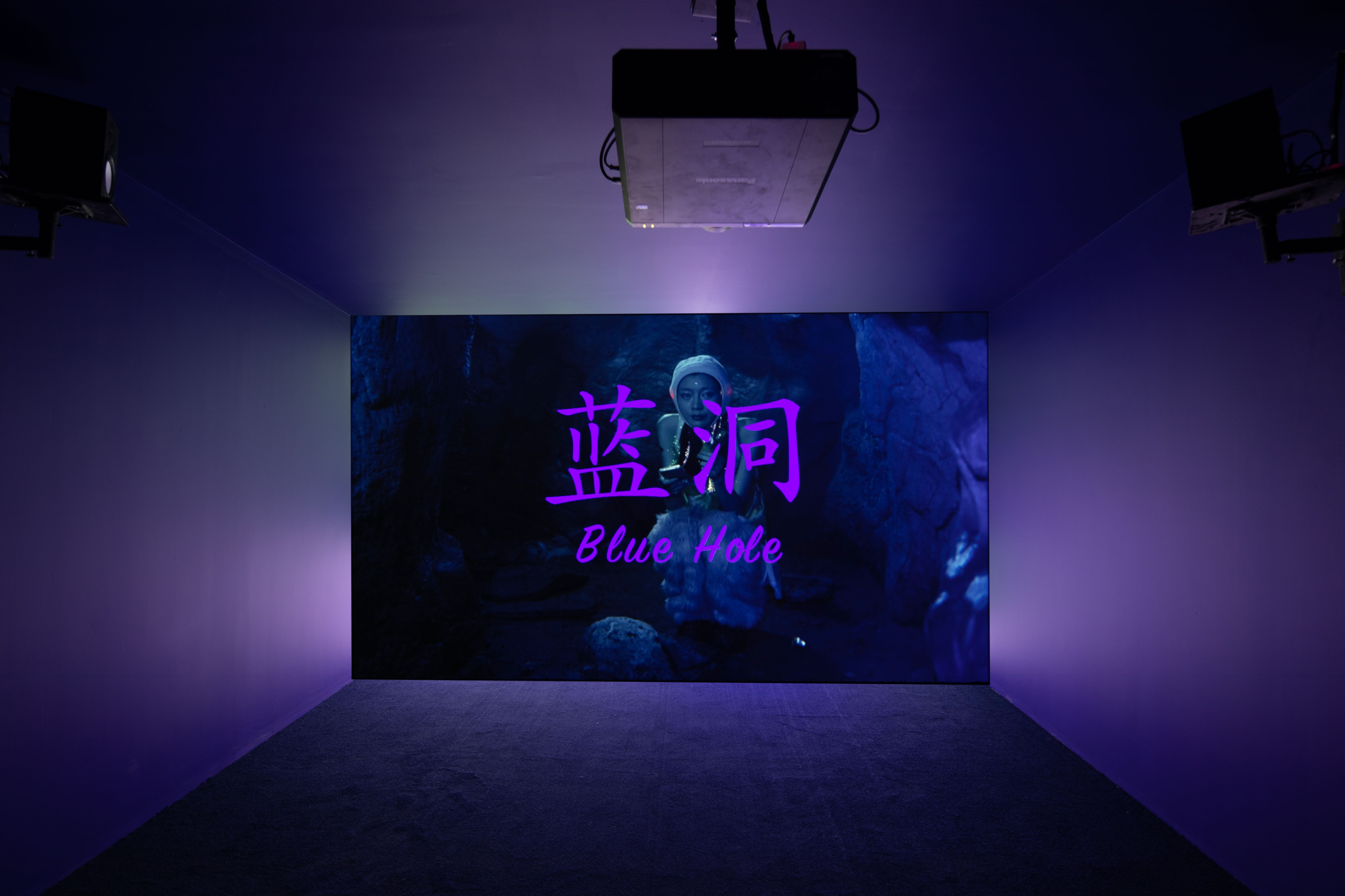 Dark room with illuminated digital art titled "Blue Hole" in English and Chinese.