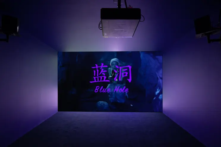Dark room with illuminated digital art titled "Blue Hole" in English and Chinese.