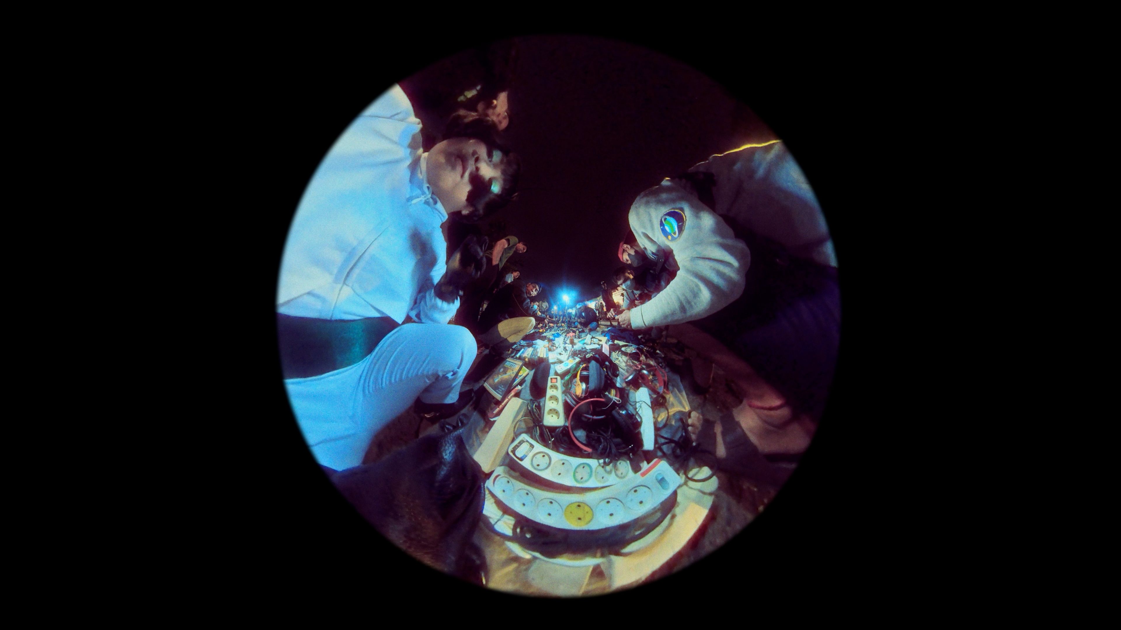 Fisheye lens photograph capturing people busily working with power cord extenders.