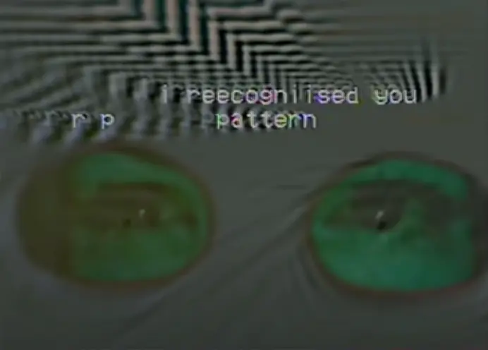 A distorted image showcasing eyes peering through green eyeglass lenses with overlaying text.