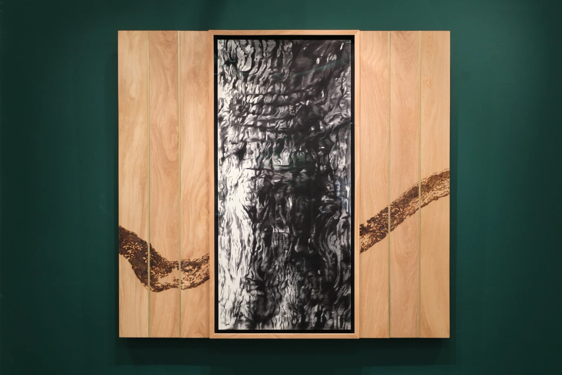 Abstract charcoal-like drawing in a wooden frame with a dark wavy line across the panels.