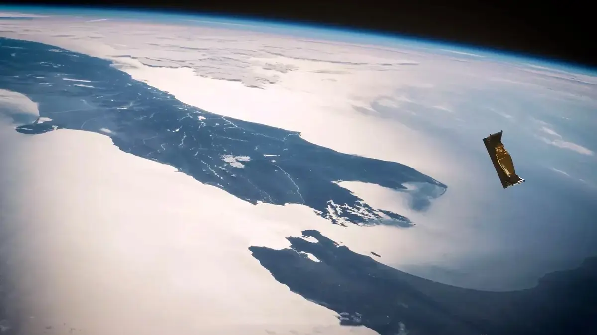 An atmospheric view of Earth from space during the daytime with a floating, gold nanosatellite.