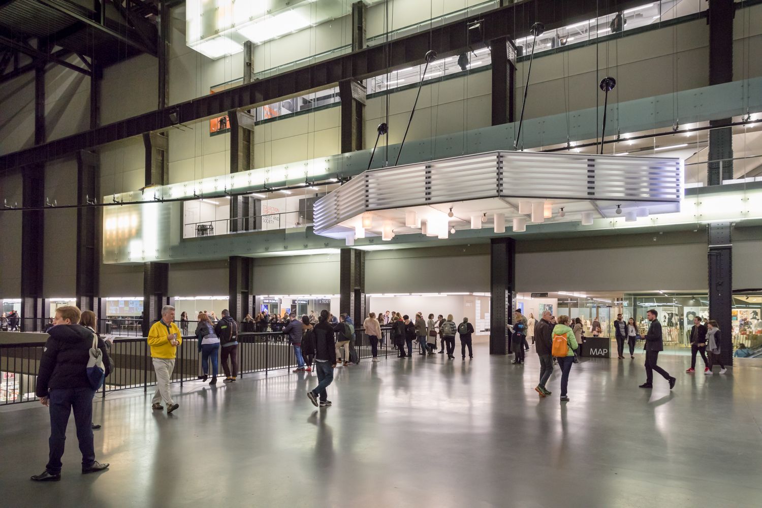 A bustling gallery hall filled with a crowd of visitors, admiring the artwork and interacting with each other.