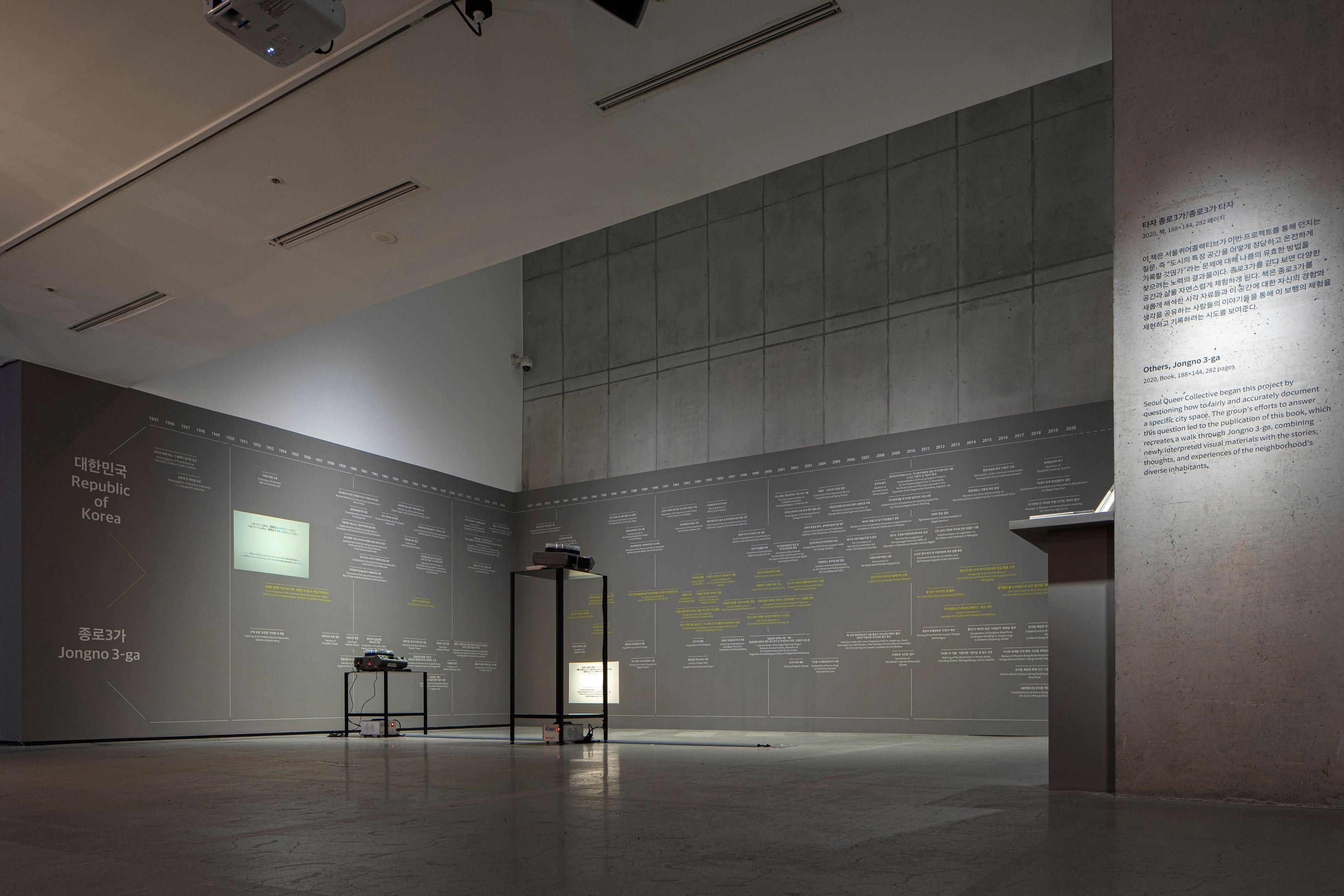 Metallic installations are arranged in the center of a gallery room with grey walls, as part of the Seoul Queer Collective...