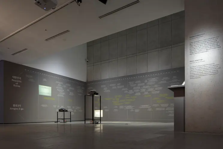Metallic installations are arranged in the center of a gallery room with grey walls, as part of the Seoul Queer Collective...
