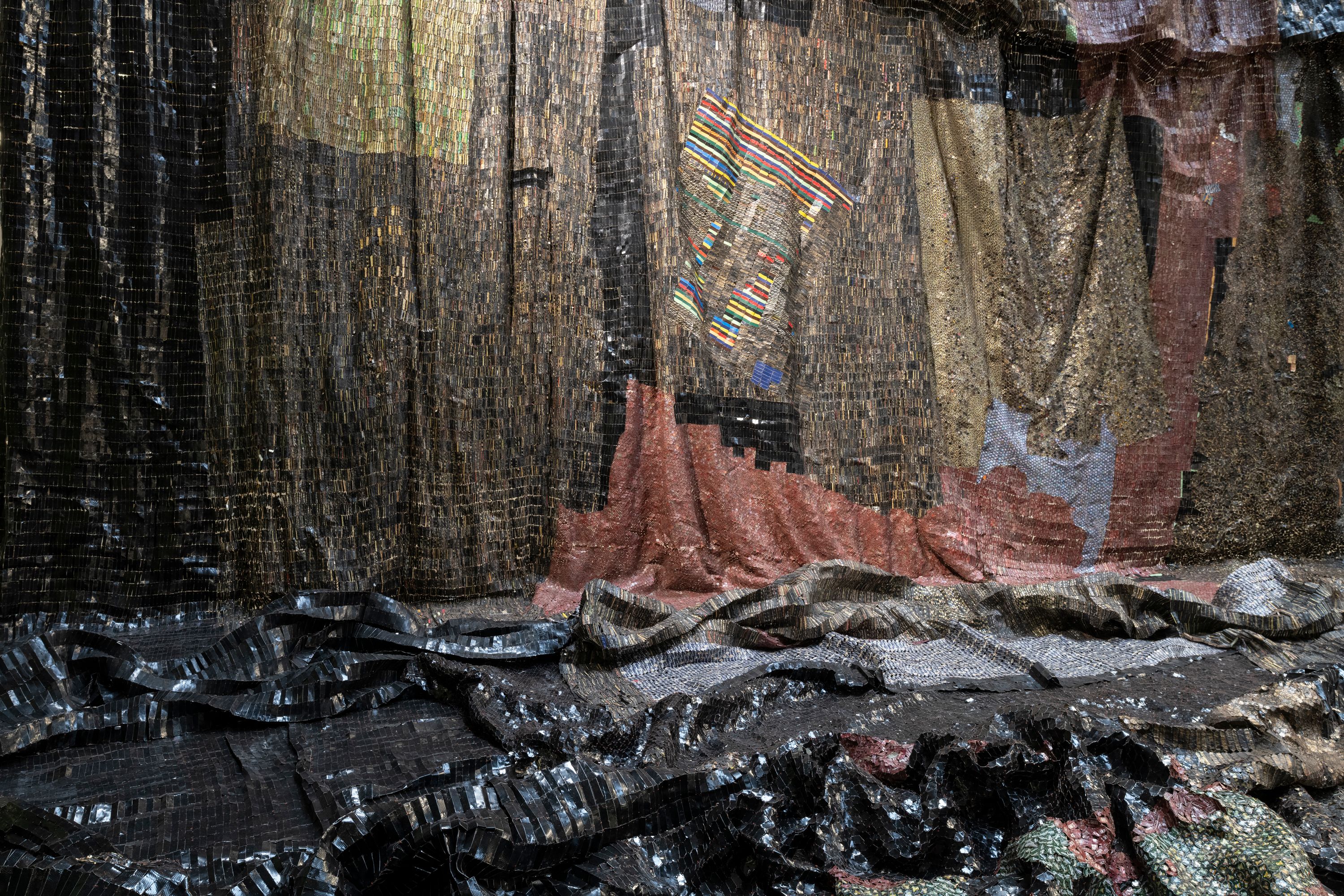 A close-up of El Anatsui’s sculpture, The Wall, featuring sheets of black metal.