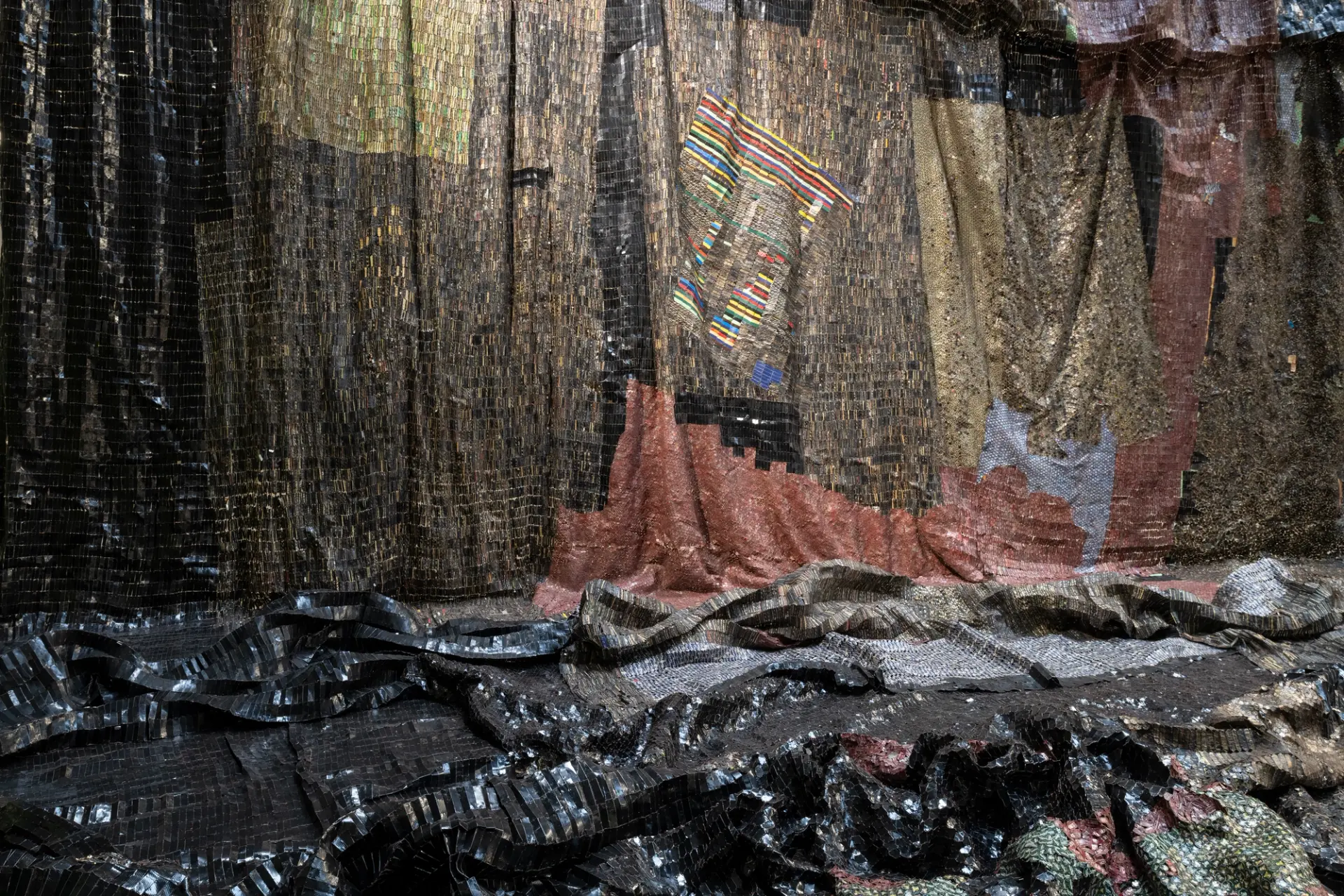 A close-up of El Anatsui’s sculpture, The Wall, featuring sheets of black metal.