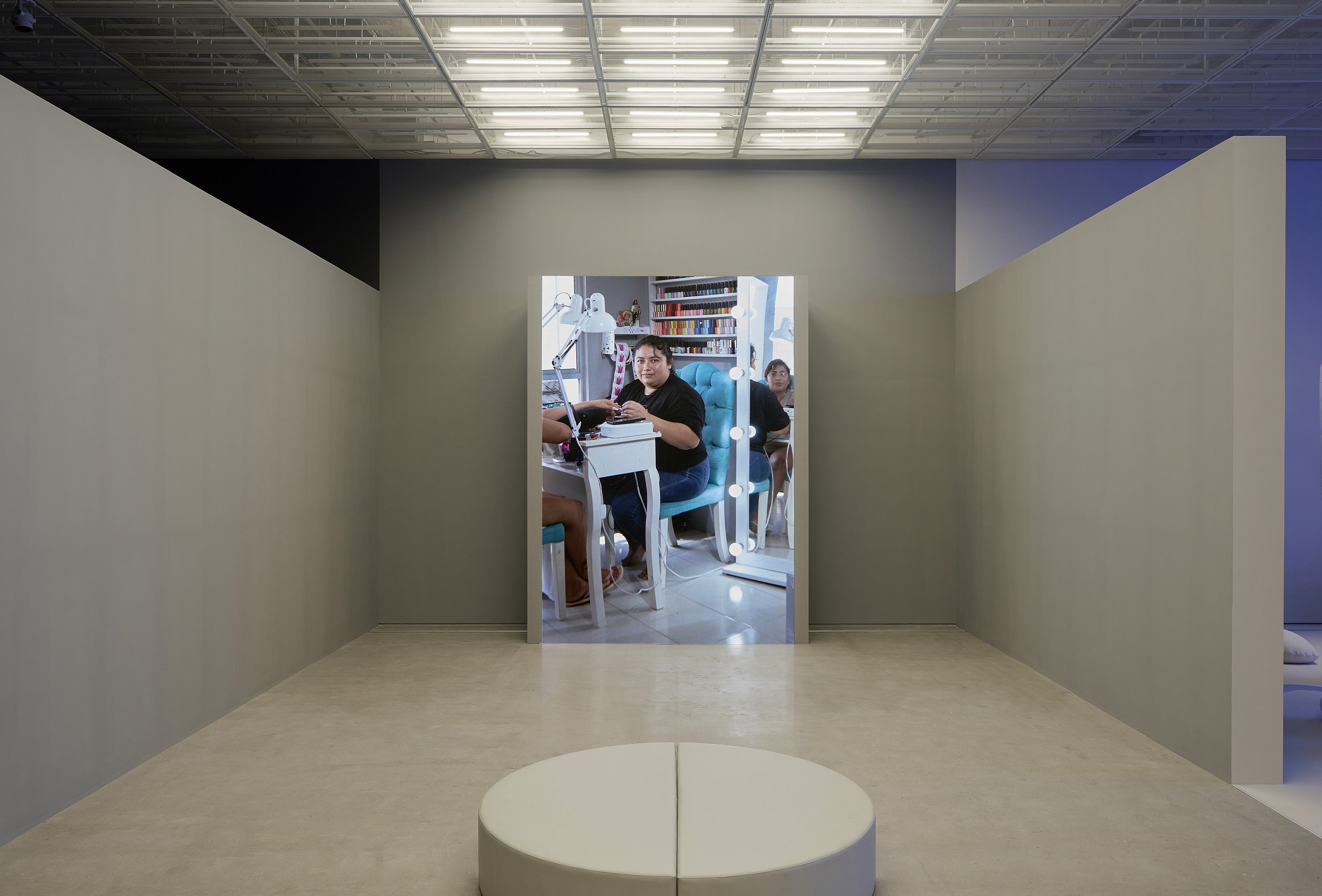 Backlit image installation displaying a modern workspace scene, viewed through a gallery setting.