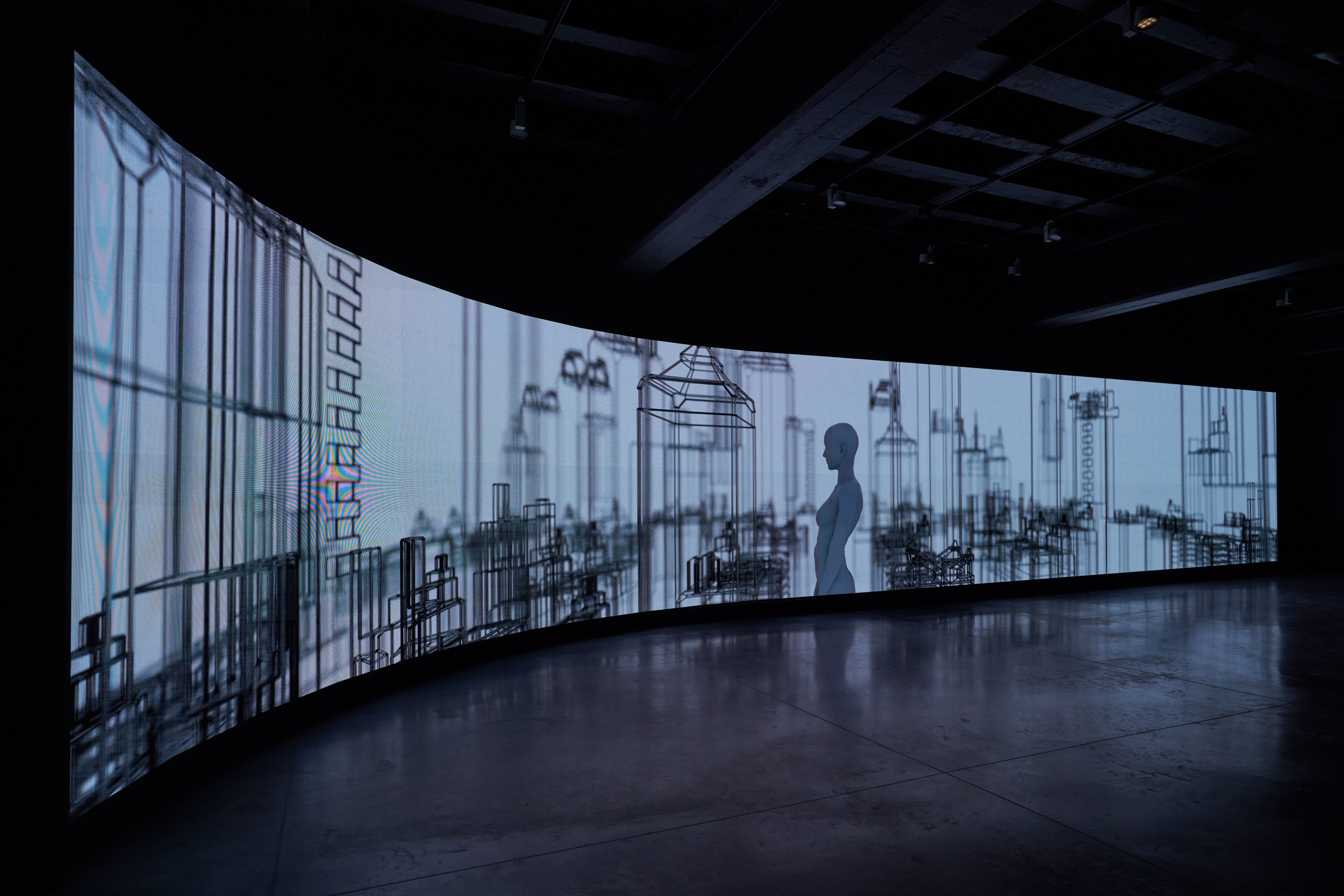 Curved projection screen displaying industrial imagery.