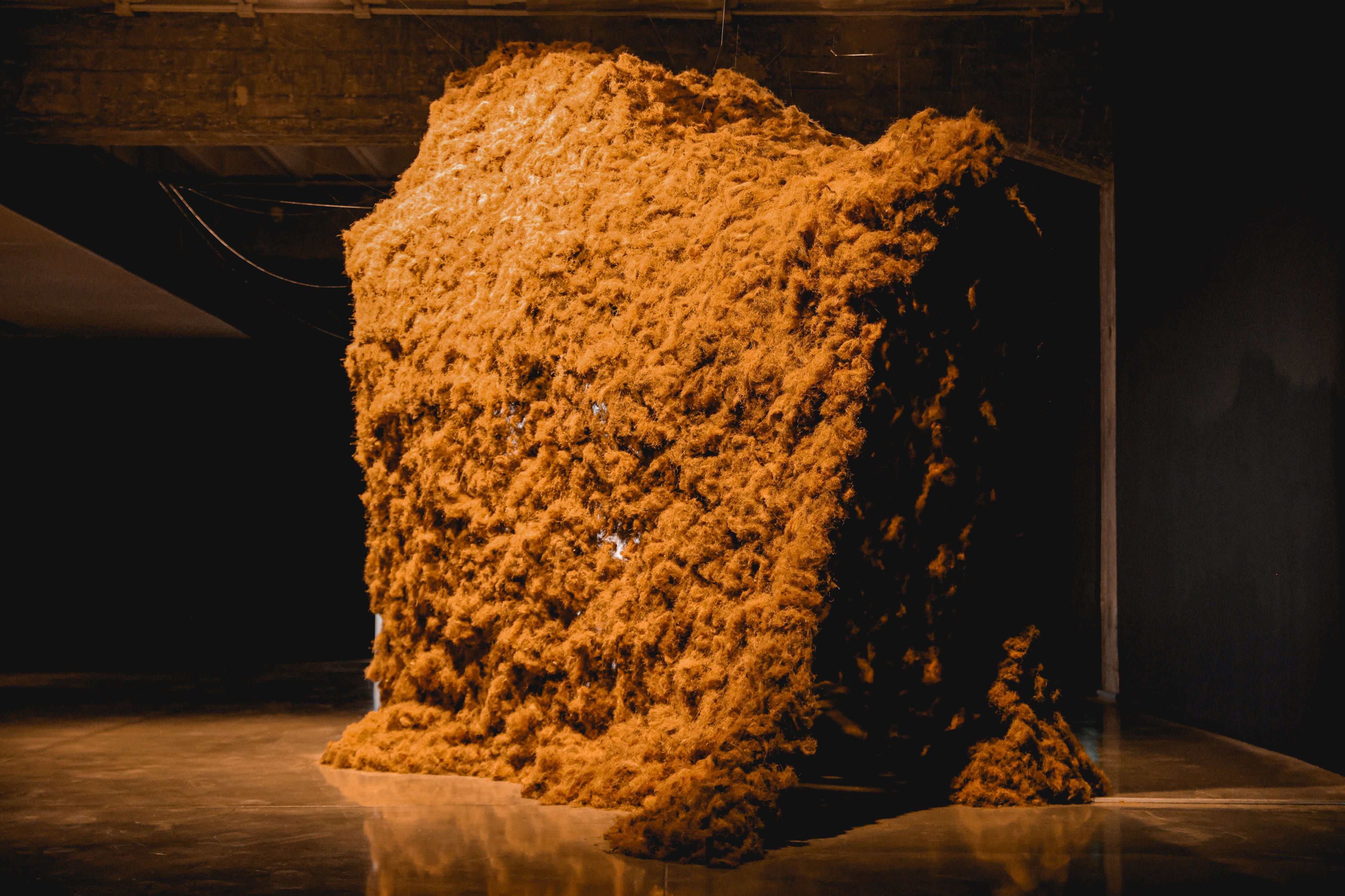 A sculpture made of brown-orange, moss-like material.