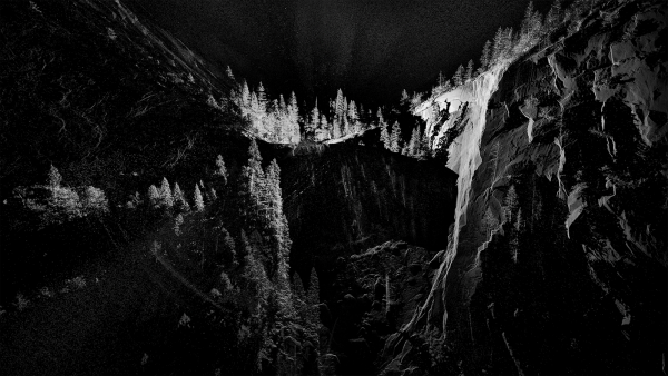 A striking black and white image showcases a cave in deep perspective. The high contrast highlights the sharp textures and...
