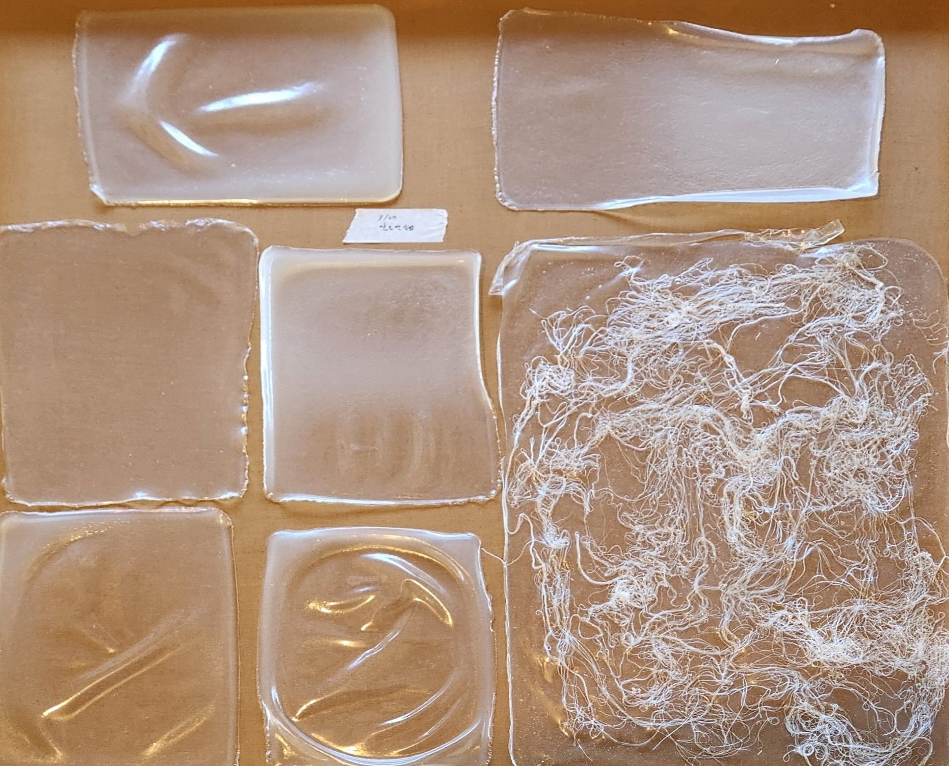 Strips of transparent plastic on a brown surface.