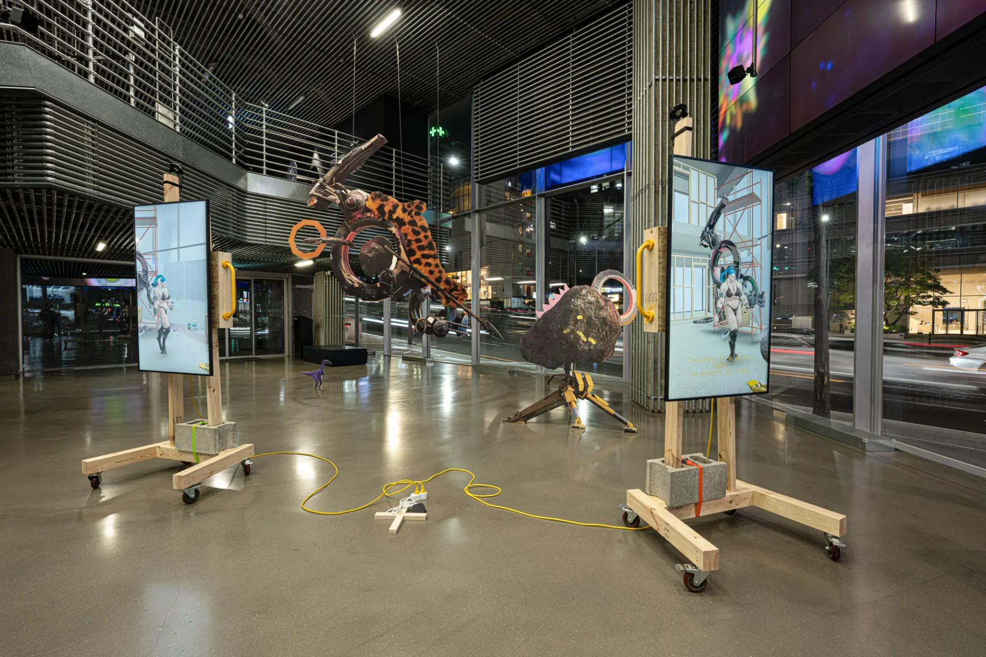 A spacious gallery hall showcasing various art installations, including an array of creative sculptures and abstract piece...