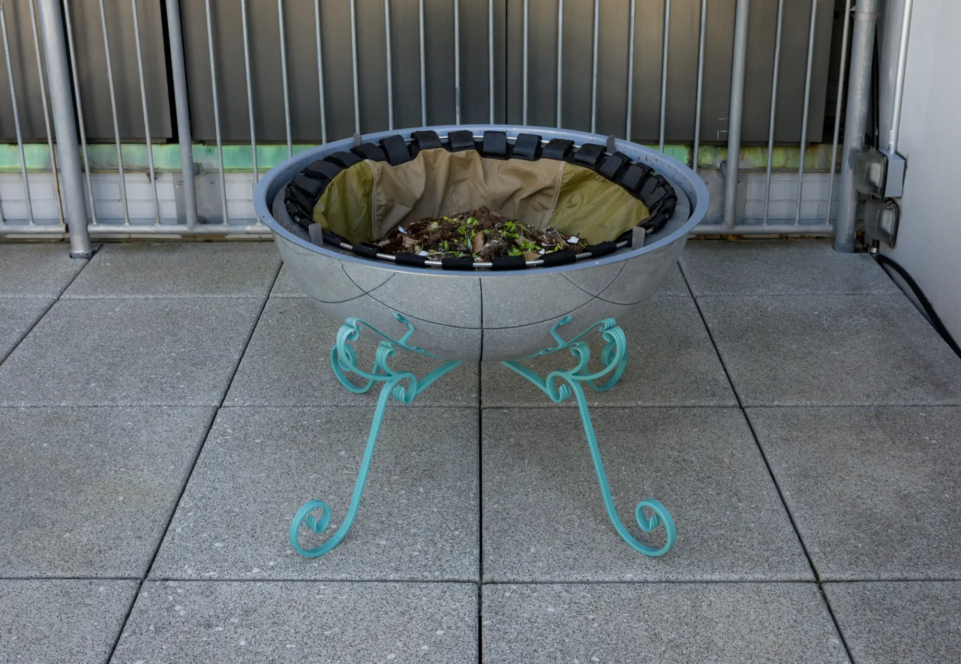 The same hemispherical sculpture shown open, revealing soil and organic material inside.