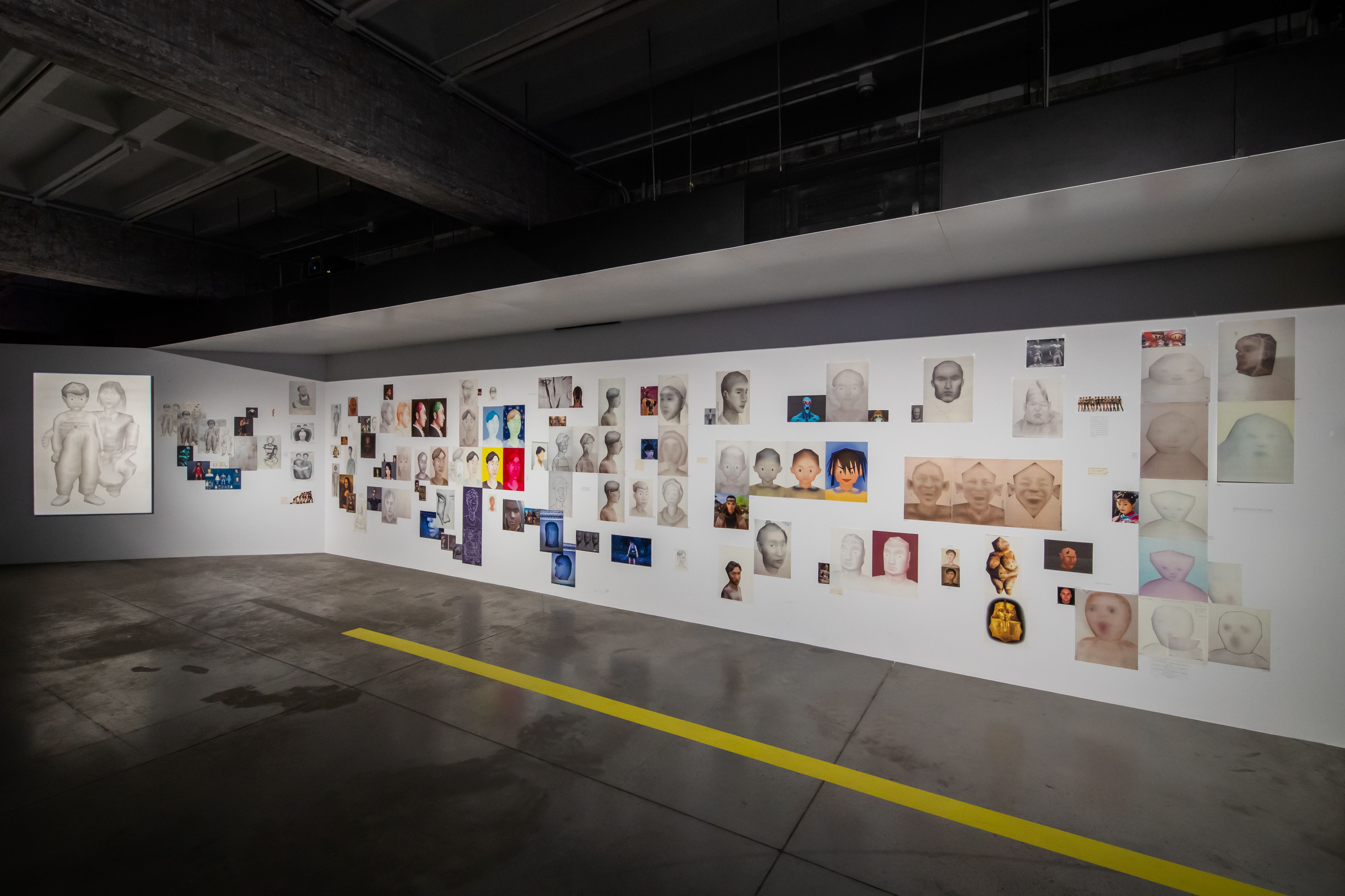 Gallery wall filled with varied portraits and multimedia art pieces.