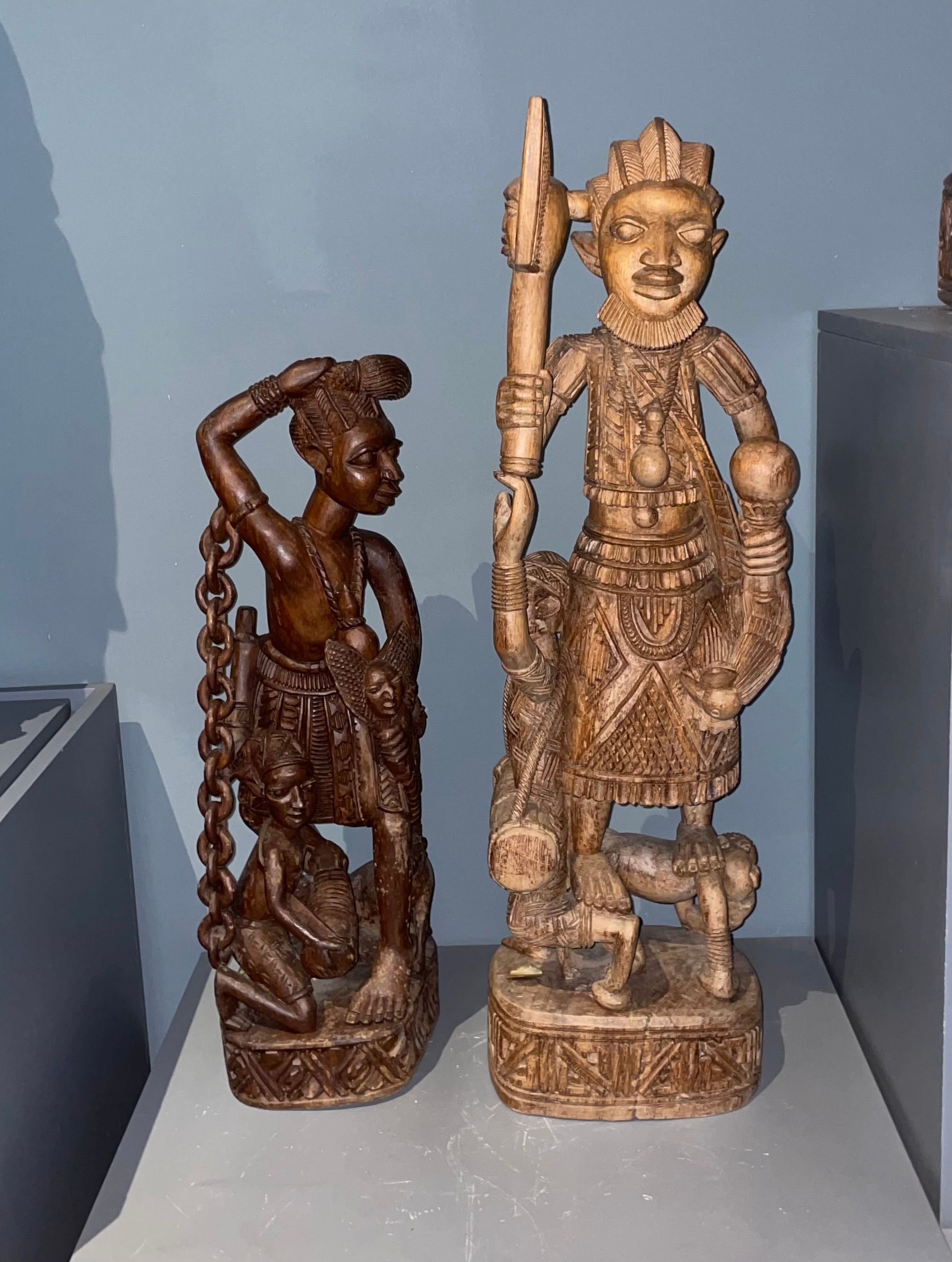 Two intricately carved wooden statues representing cultural or historical themes.