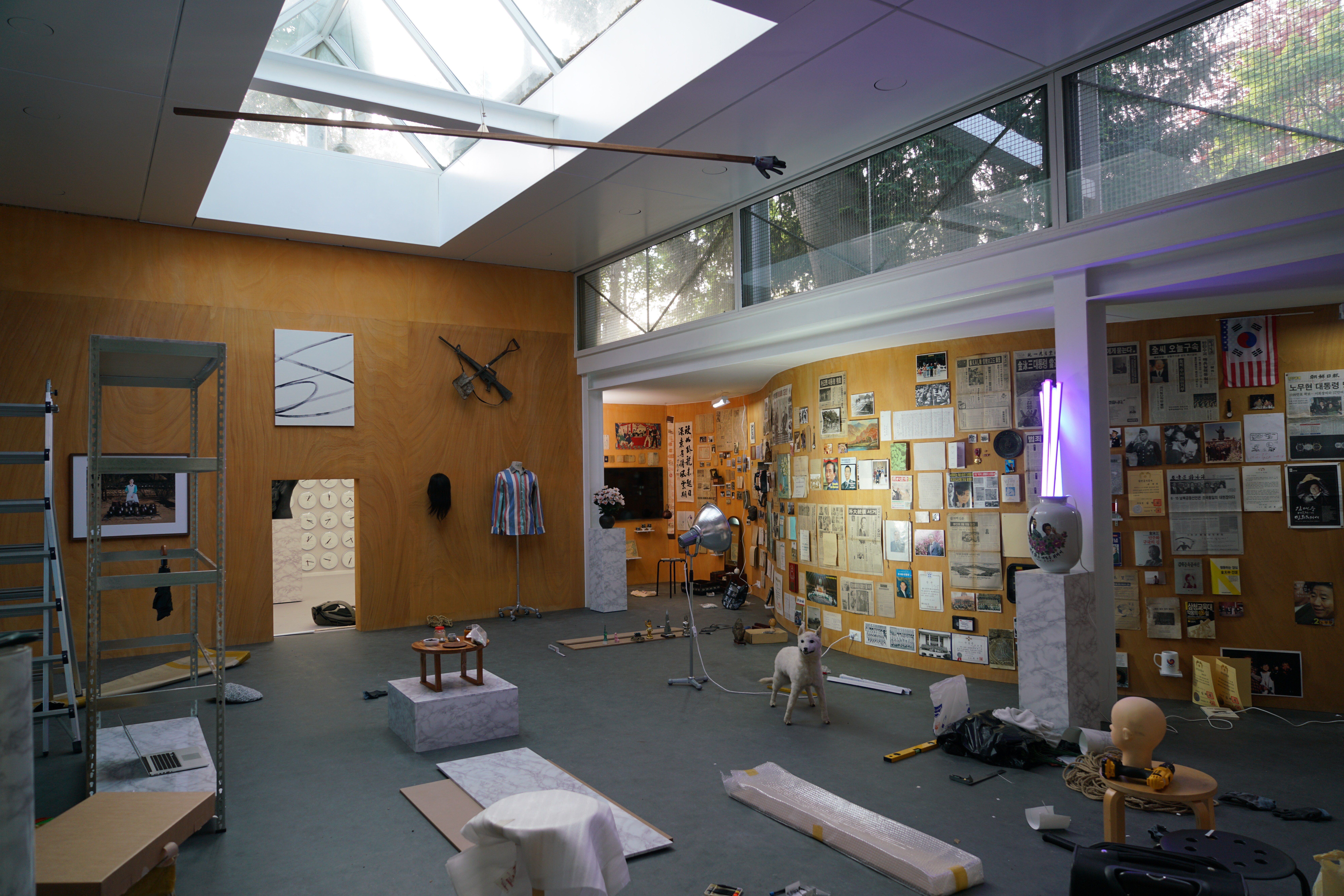An interior gallery room filled with a variety of diverse art pieces and installations, creating a rich tapestry of artist...