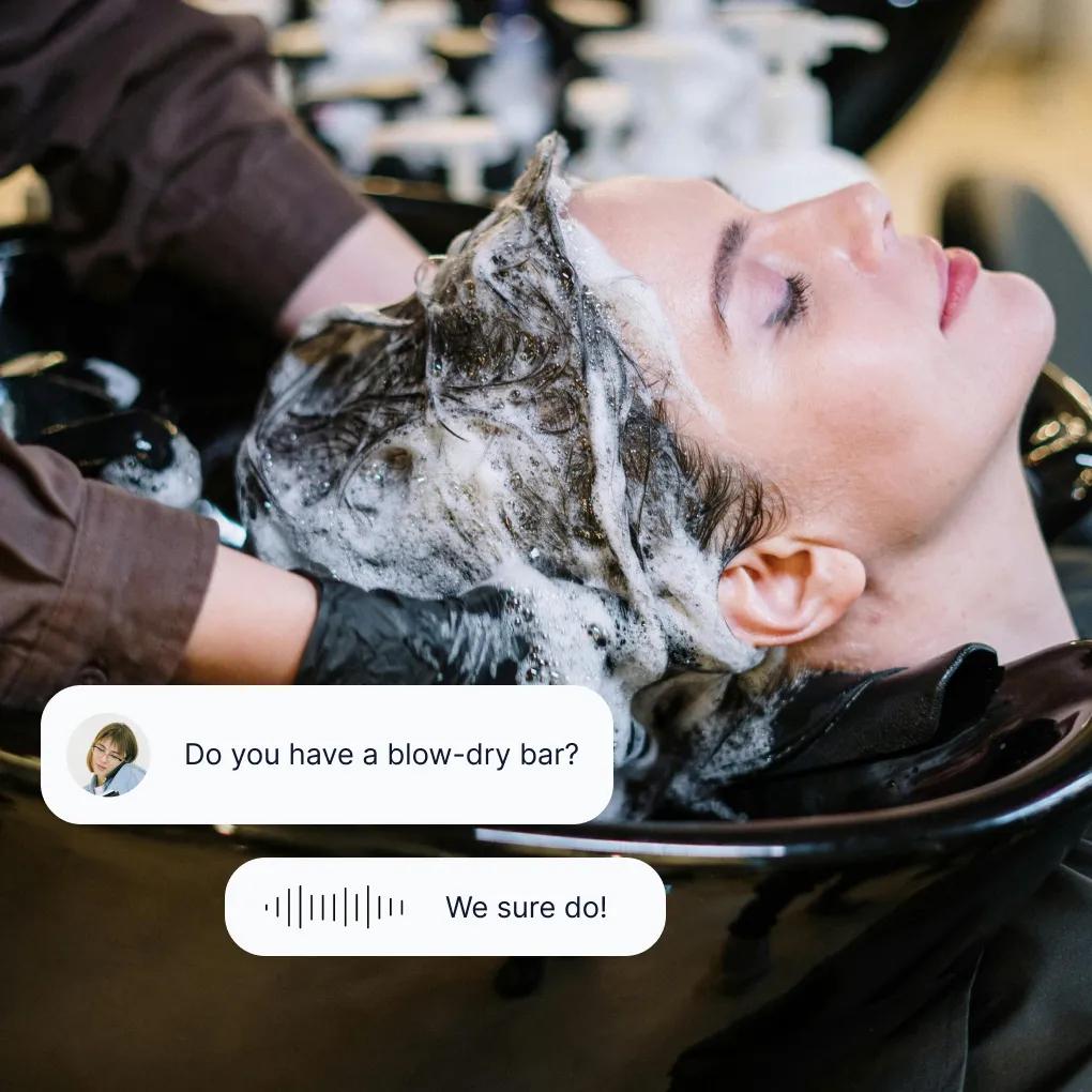 Client receiving professional hair wash treatment while salon answering service confirms blow-dry bar services
