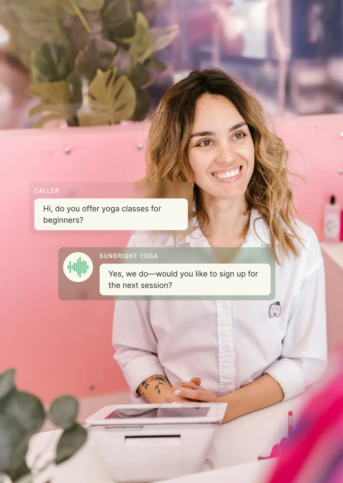 Smiling receptionist using electronic receptionist software to schedule a yoga class for a beginner caller