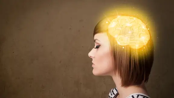 Young girl thinking with glowing brain illustration on grungy background.jpeg
