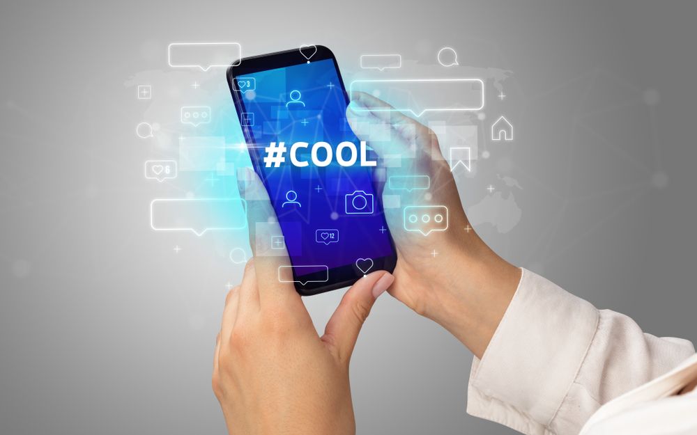 Female hand typing on smartphone with %23COOL inscription%2c social media concept.jpeg