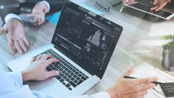 business documents on office table with smart phone and laptop computer and graph financial with social network diagram and three colleagues discussing data in the background.jpeg