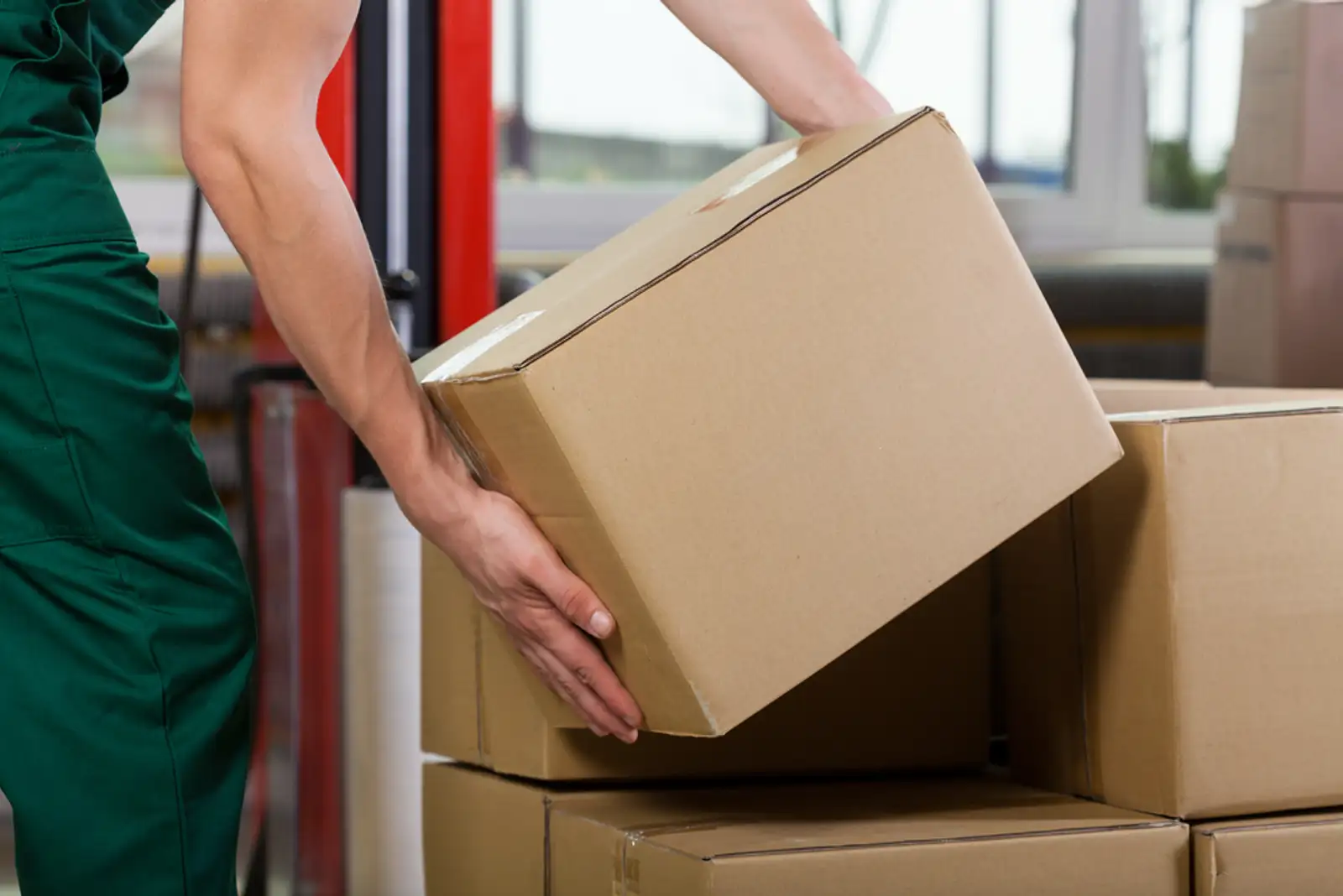 Hands of warehouse worker lifting box%2c horizontal.jpeg